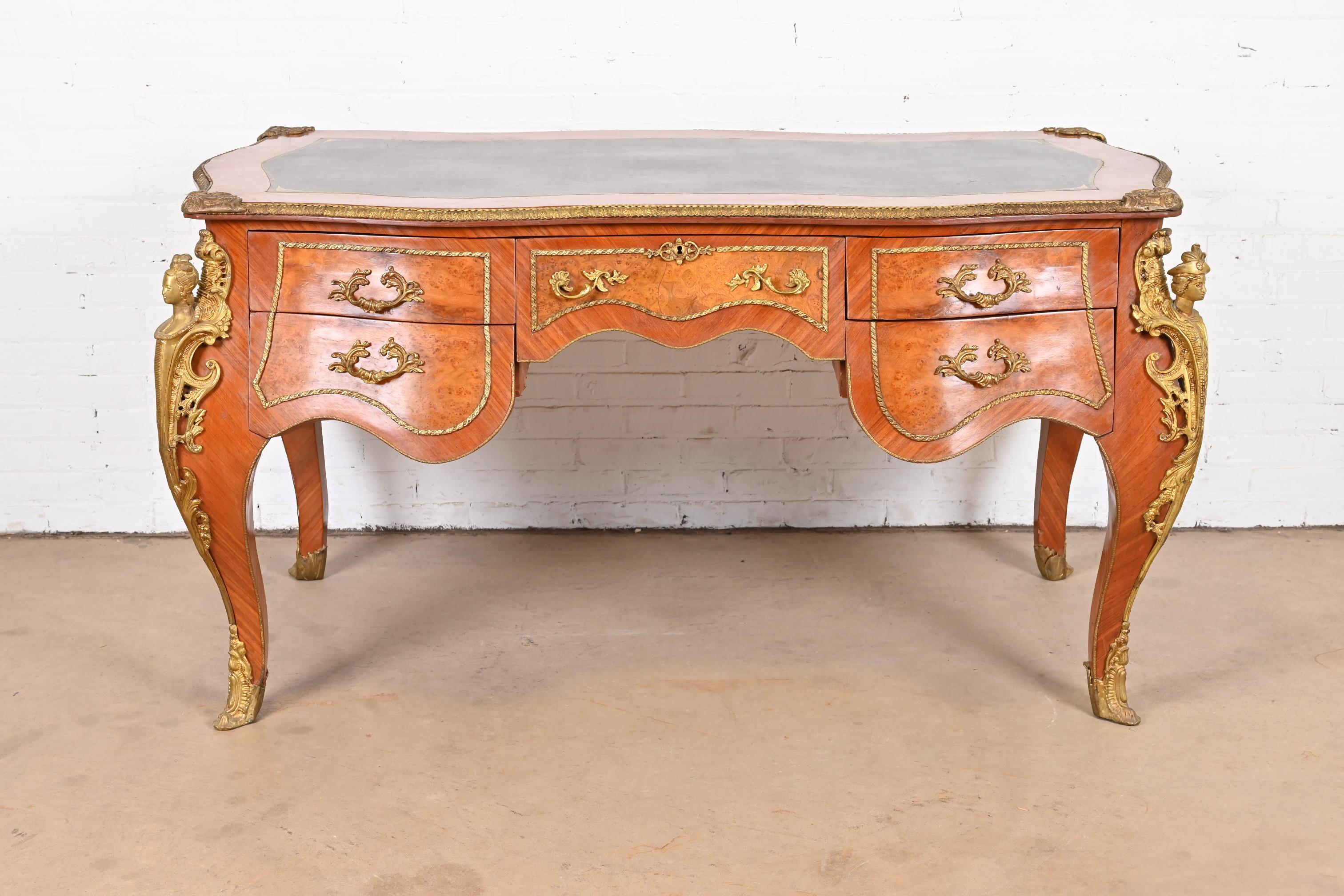 An outstanding French Louis XV style executive writing desk or bureau plat desk

France, circa Early 20th century

Kingwood and burled walnut, with bronze trim and ornate ormolu mounts, and embossed black leather top.

Measures: 67