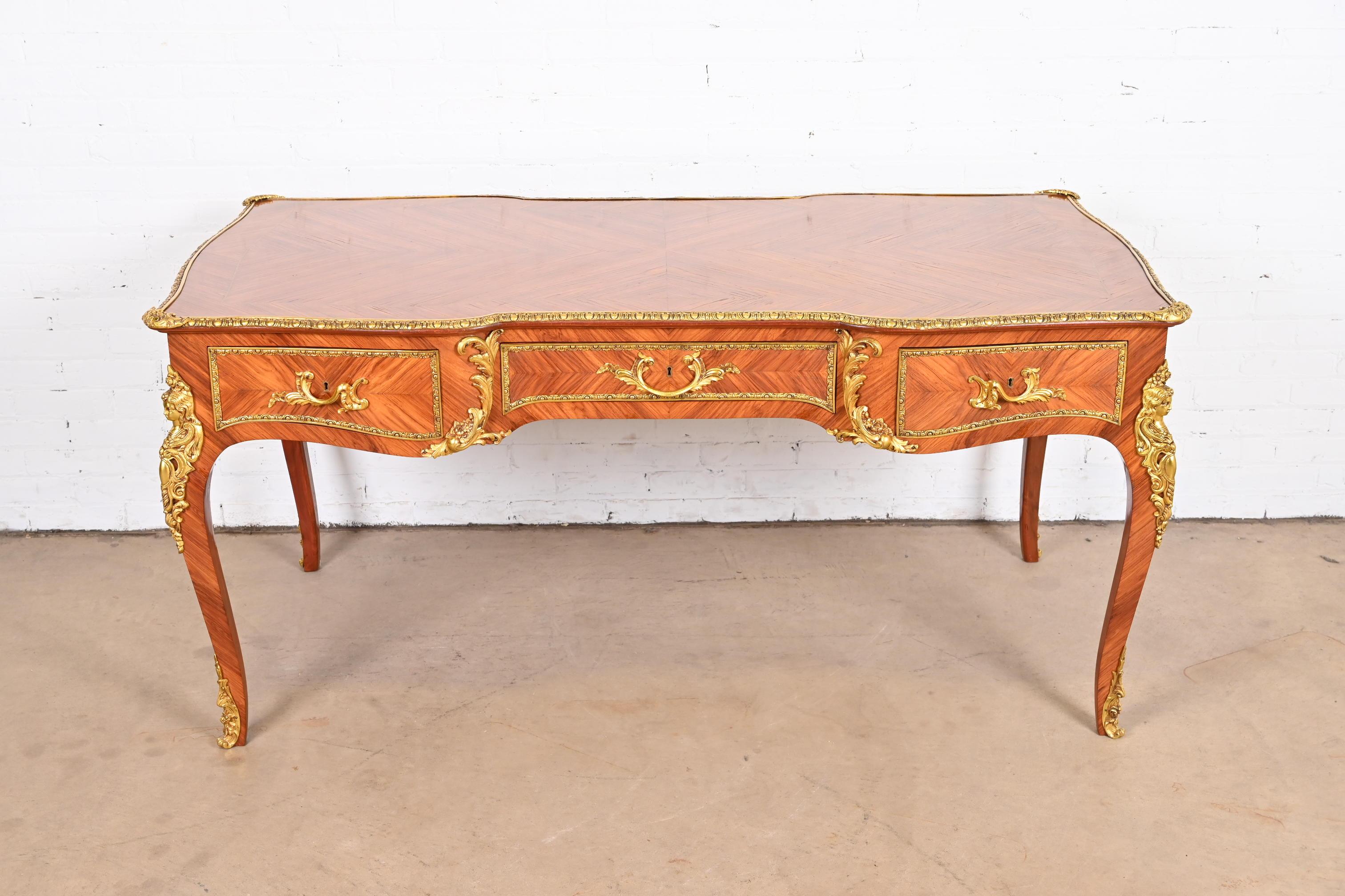 A gorgeous French Louis XV style executive writing desk or bureau plat desk

France, circa Mid-20th century

Beautiful book-matched kingwood, with mounted gilt bronze ormolu and hardware.

Measures: 66.5