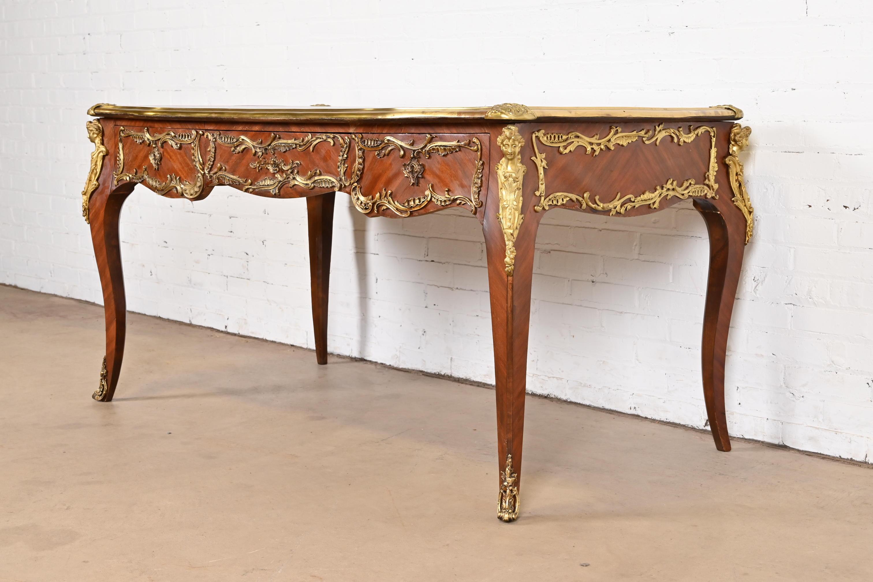 An outstanding French Louis XV style writing desk or bureau plat desk

By R. Soriano

Spain, 20th Century

Gorgeous kingwood, with ornate gilt bronze ormolu mounts, and embossed black leather top.

Measures: 59