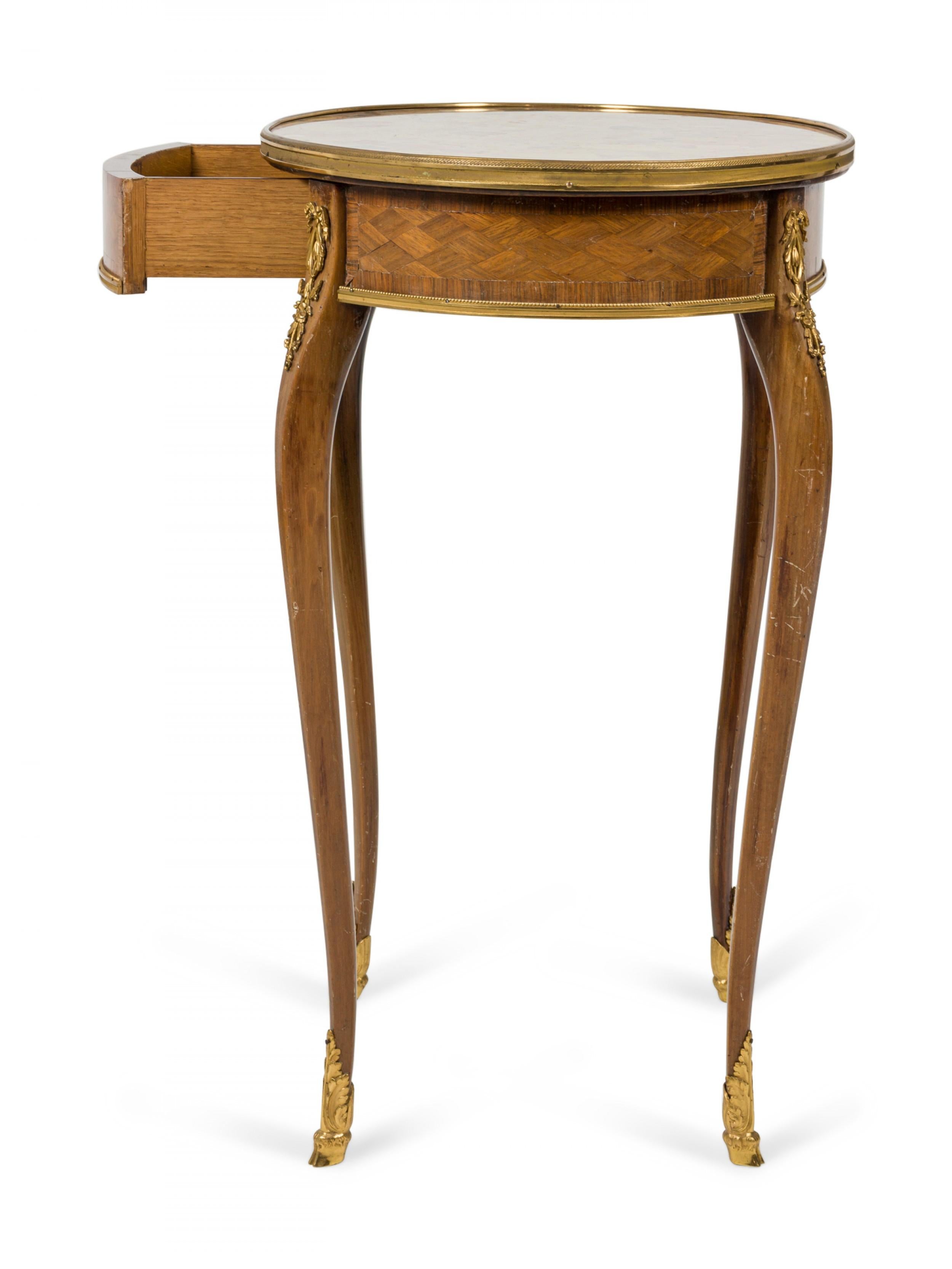 Ovaler Beistelltisch aus französischem Louis XV (19. Jh.) mit Intarsien aus Königsholz, Schublade und vergoldeter Bronzeschmuck, mit einer Platte aus Marmor.

Antiker Zustand.