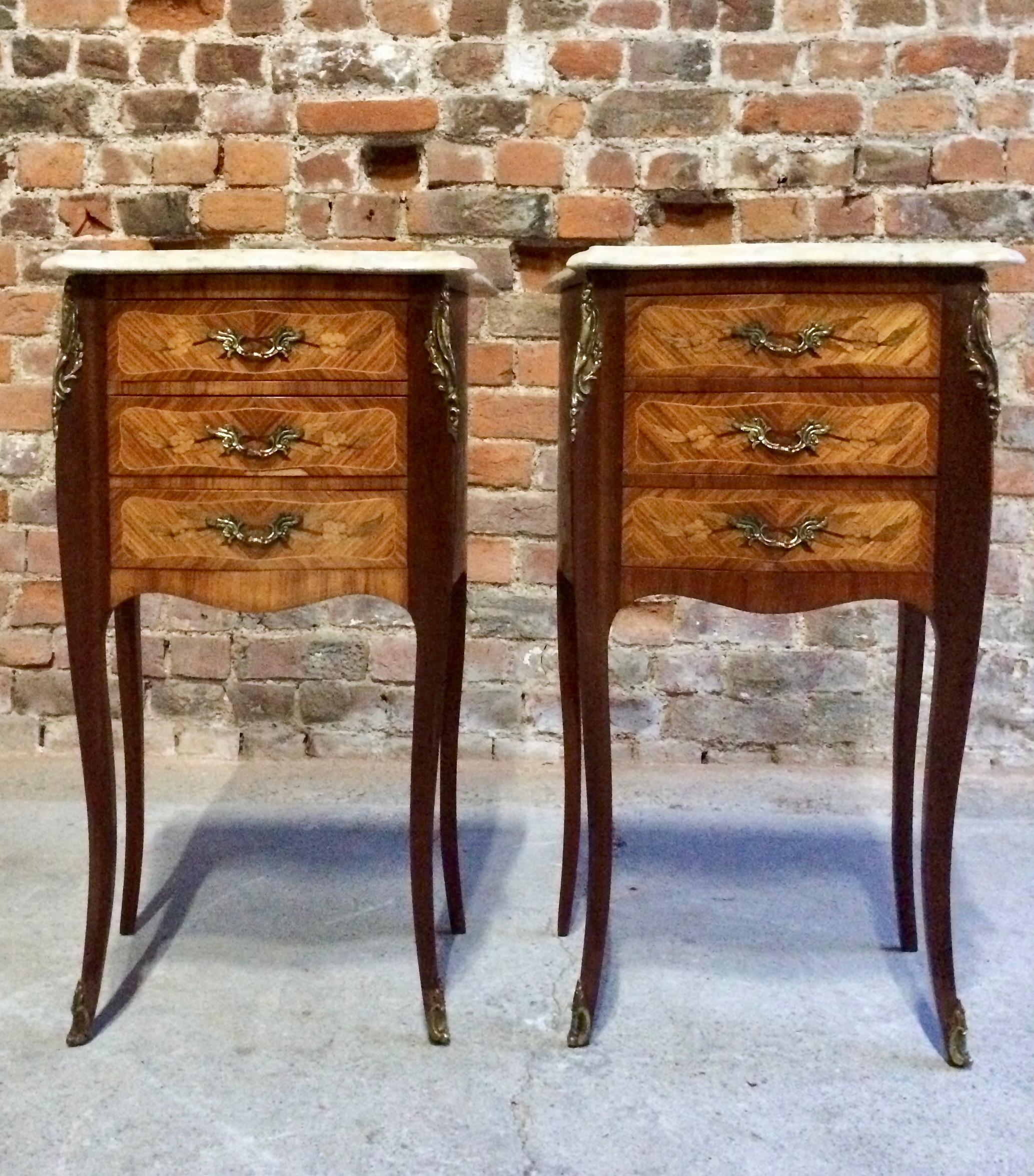 Antique French pair of Louis XV style marble-topped bombe commode bedside cabinets dating to early 20th century, the scalloped cream marble tops over three drawers with dual bronze handles and gilt mounts, bronze accents to the sides and legs, all