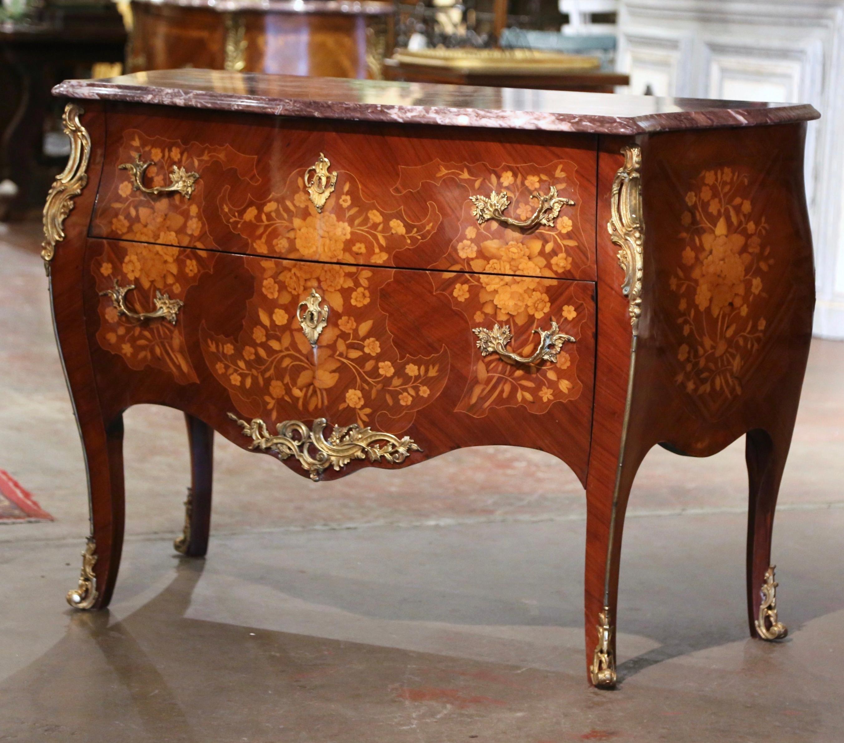 Crafted in France circa 1980, the vintage commode stands on cabriole legs ending with bronze mounts feet, over a scalloped apron decorated with a bronze shell and leaf motif mount. The fruit wood chest features two bombe drawers across the front