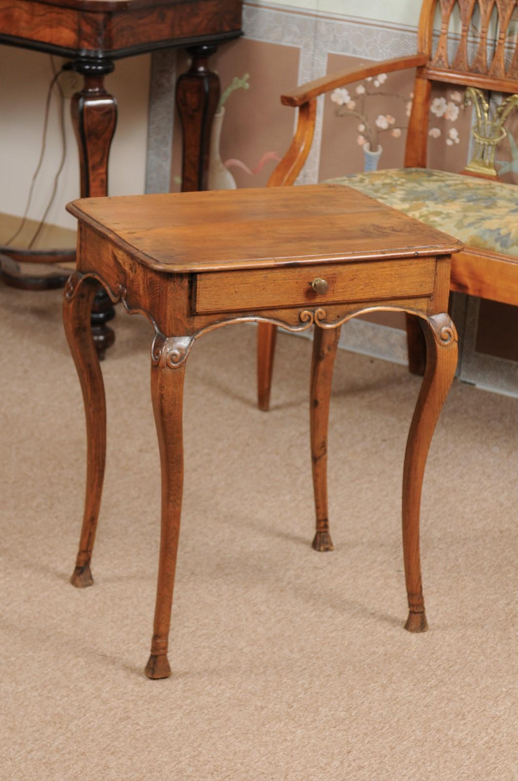 The French Louis XV oak and fruitwood side table with 1 drawer, carved shaped apron, cabriole legs and hoofed feet.