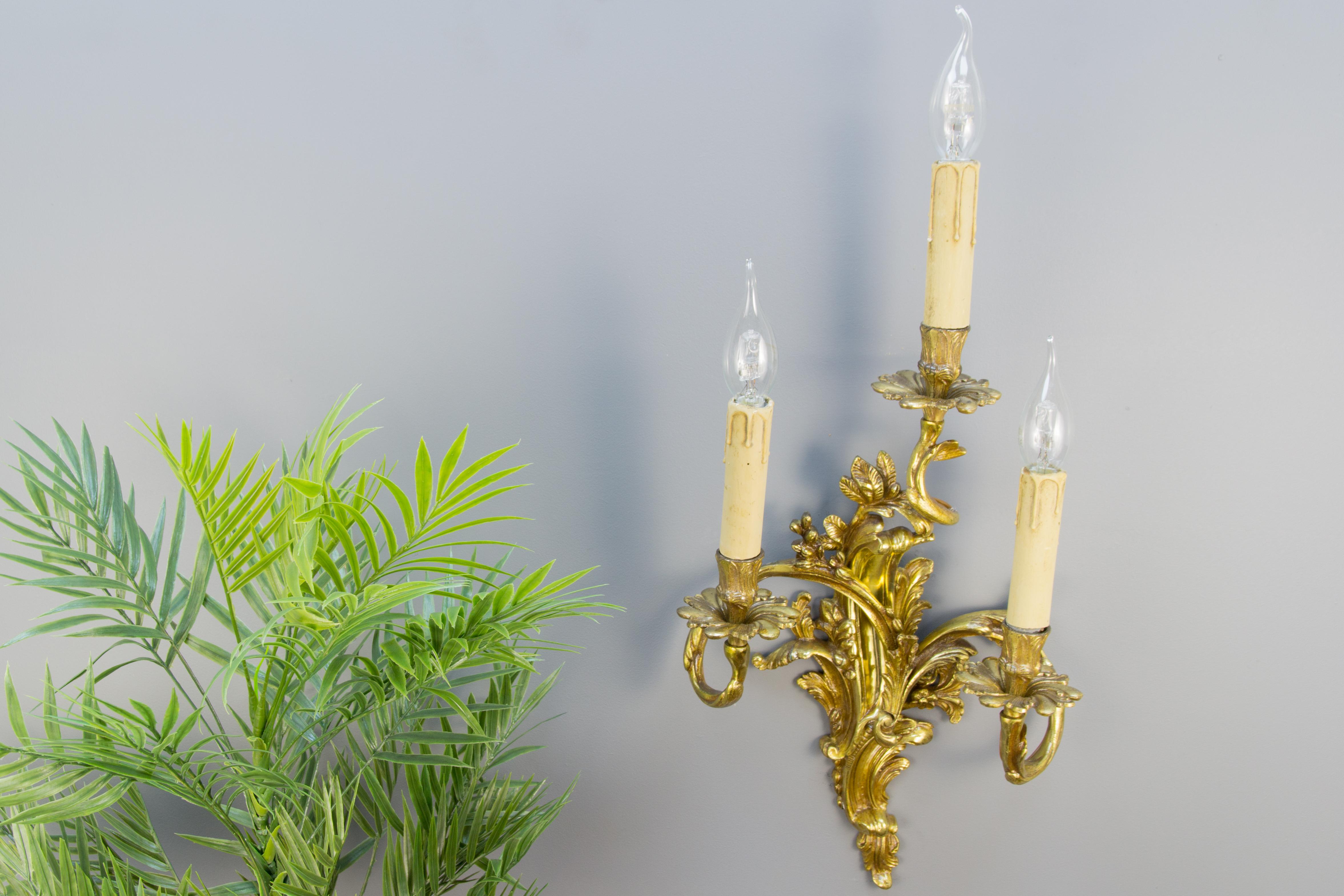 Large Louis XV French Rococo style three–arm sconce. Curvy asymmetrical acanthus leaf-like gilt bronze scrolls in Classic French Rococo style. Each arm has a socket for the E14 light bulb. Wooden candle covers. France, circa the 1920s.
Measures