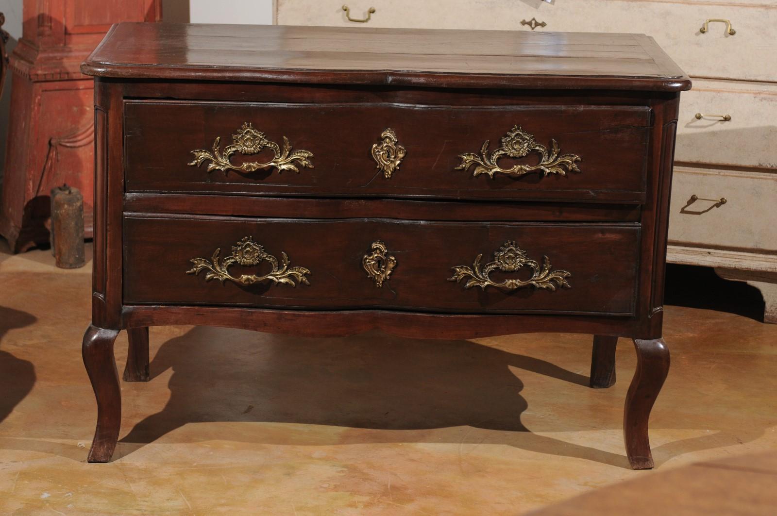 A French Louis XV period mid-18th century two-drawer fruitwood commode with bronze Rococo hardware, from the Cévennes region. Born in the mountainous south-central area of France during the reign of King Louis XV, nicknamed 