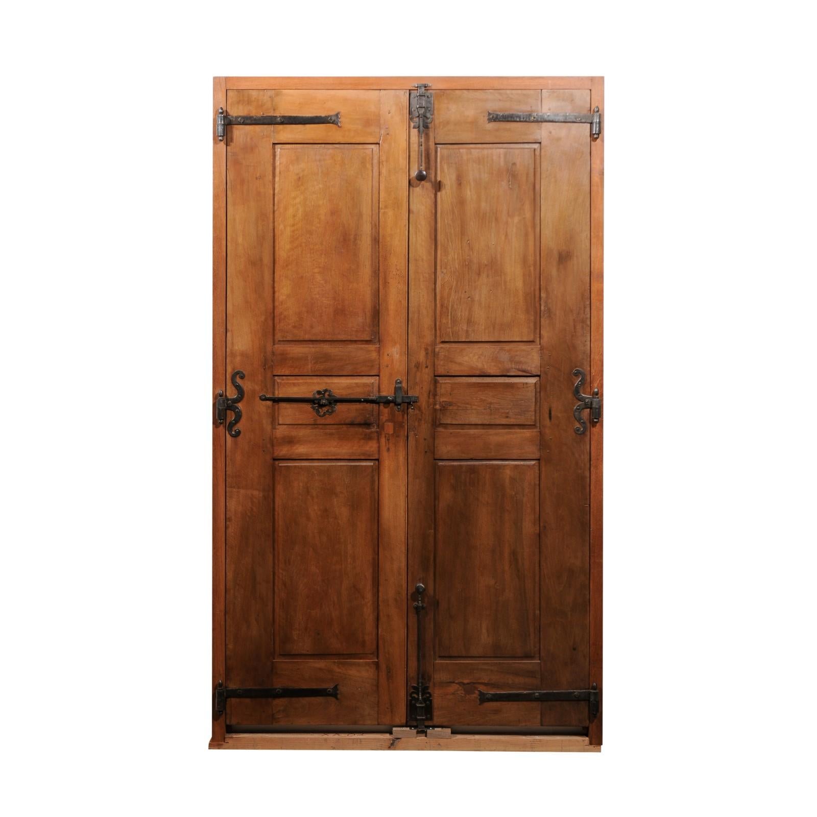 A pair of French Louis XV period walnut communication doors from the mid 18th century, with raised panels and iron hardware. Created in France in the 18th century during the reign of King Louis XV nicknamed Le Bien-Aimé (the Beloved), this walnut