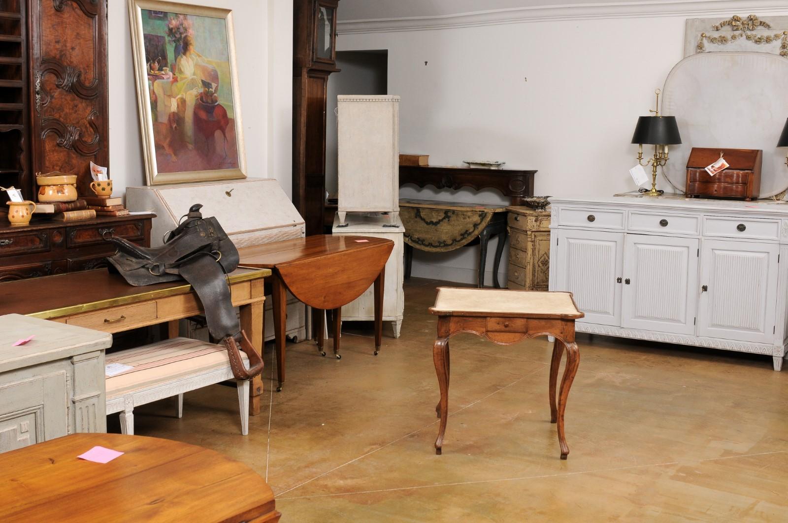 Ein französischer Spieltisch aus Nussbaumholz aus der Mitte des 18. Jahrhunderts im Stil Ludwigs XV., mit beigem Samtstoff, einer Schublade, geschnitzter Schürze und Kabriole-Beinen. Dieser Spieltisch aus Nussbaumholz, der während der Herrschaft von