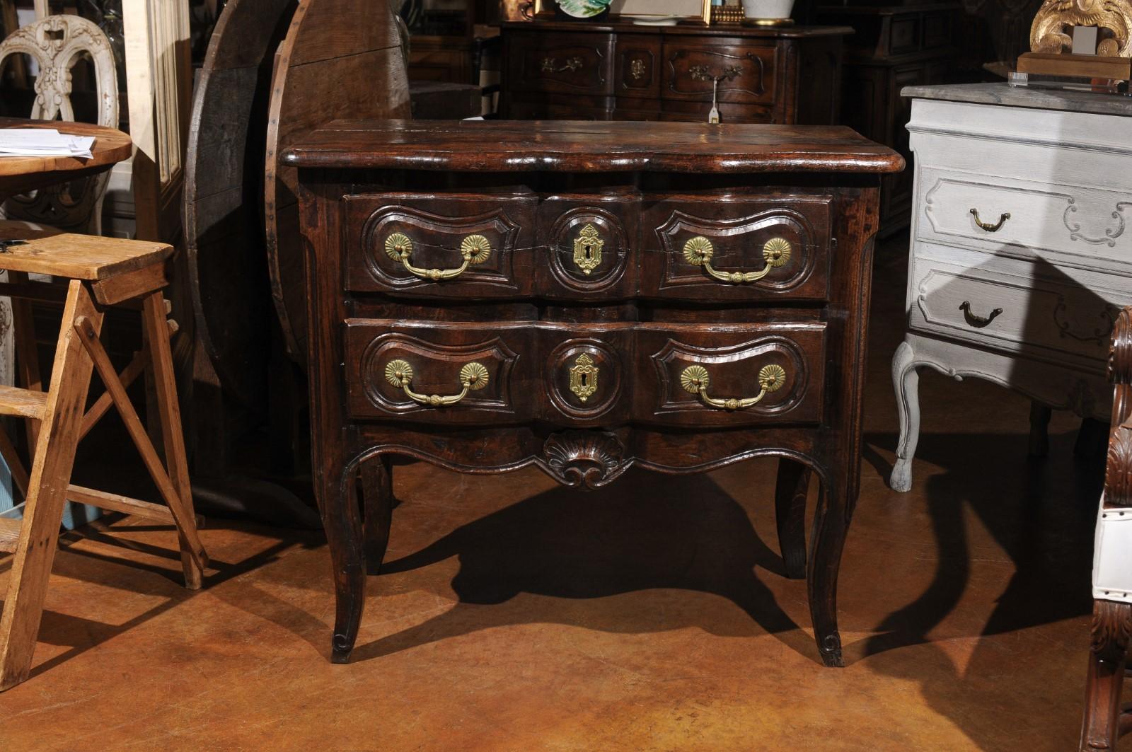 A French Louis XV period oak commode from the mid-18th century, with two drawers and serpentine front. Born in France during the reign of King Louis XV nicknamed 