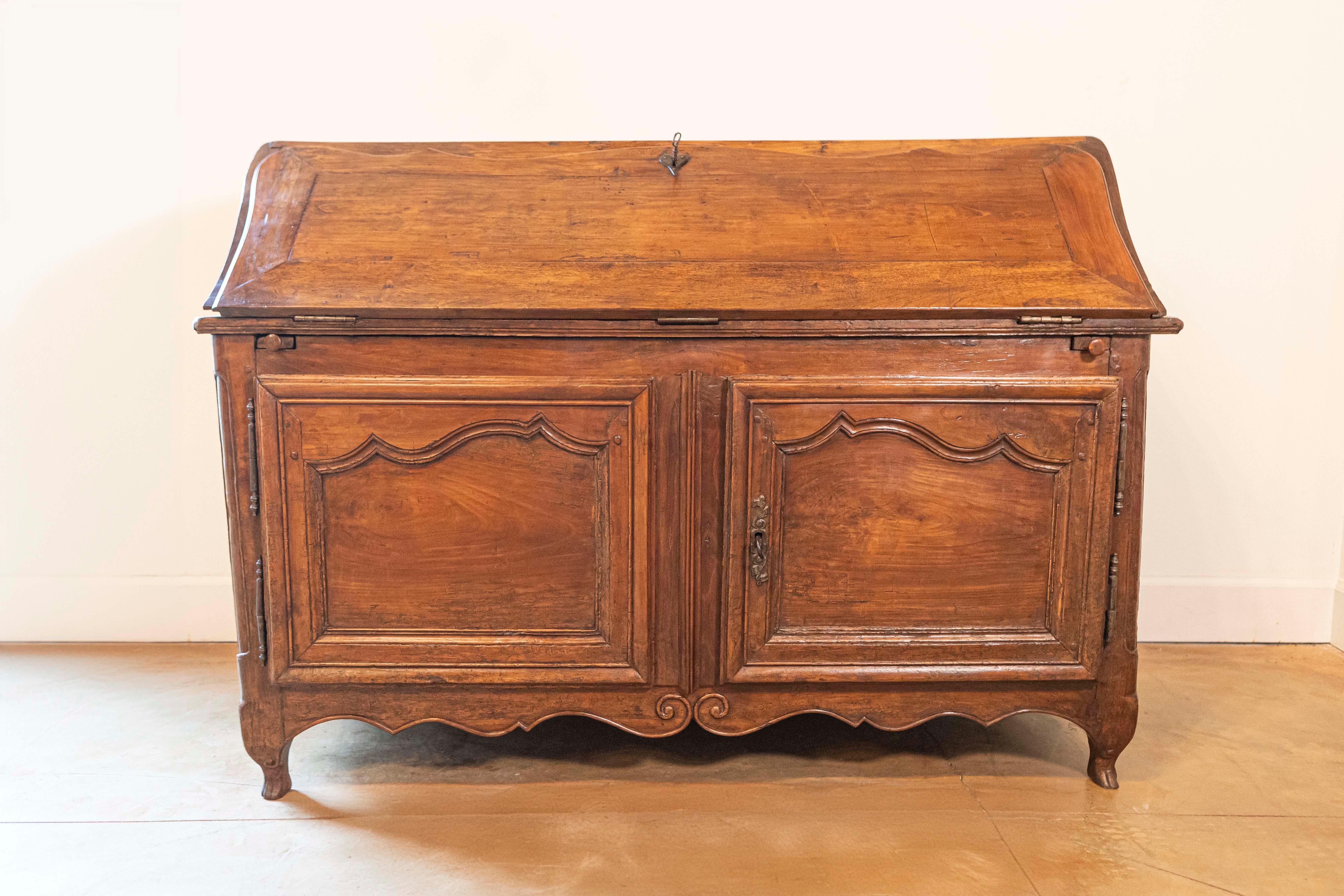 Segreteria in noce a fronte obliqua di epoca Luigi XV del XVIII secolo con buffet nella parte inferiore. Entra nel mondo dell'eleganza regale con questa segretaria in noce di epoca Luigi XV del XVIII secolo, un capolavoro che fonde perfettamente la