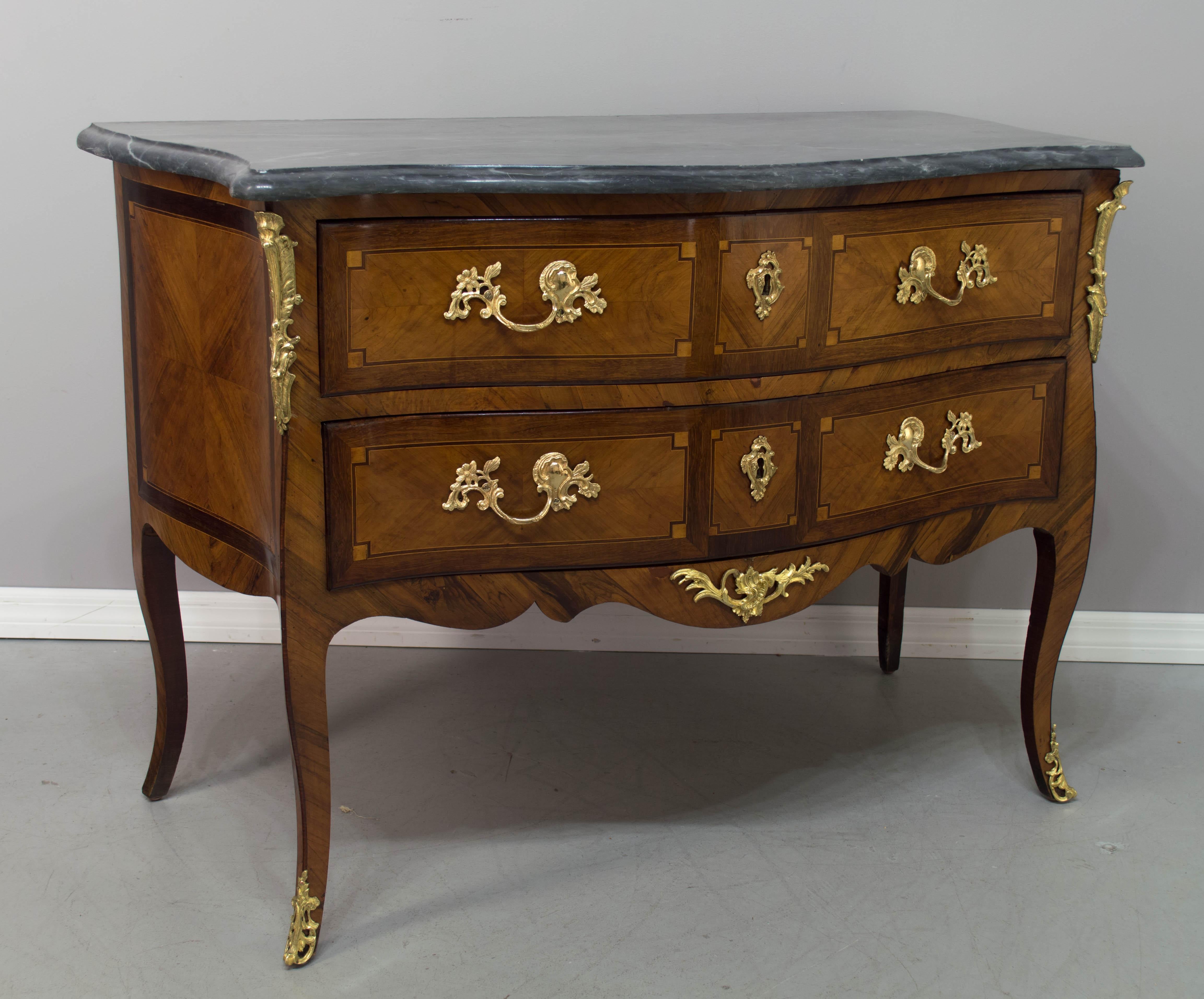 A very nice 18th century Louis XV commode with serpentine front and curved sides with marquetry inlay with veneer of cherry, mahogany and walnut. French polish finish. Two dovetailed drawers with locks, but no key. Original polished bronze hardware.