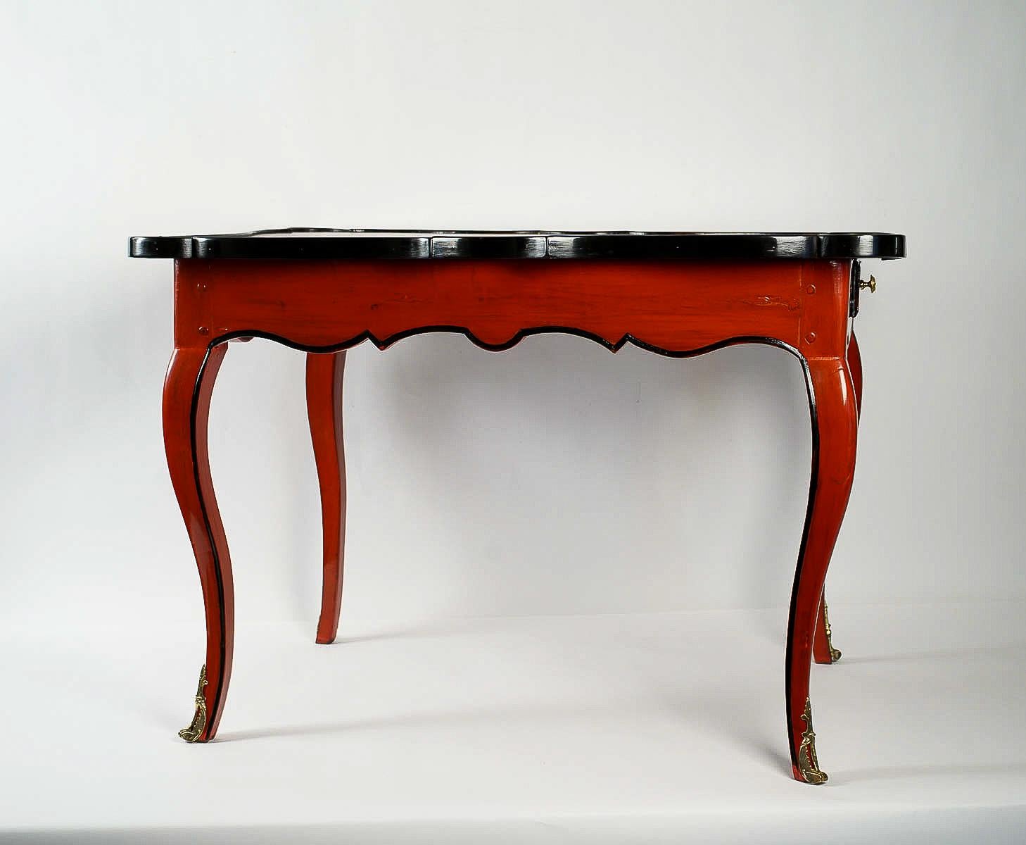 We are pleased to present you, a lovely and exciting chestnut lacquered red and black game table circa 1740, having a drawer on each side and an embossed leather playing surface. Our game table rests on serpentine legs.

French Louis XV period,