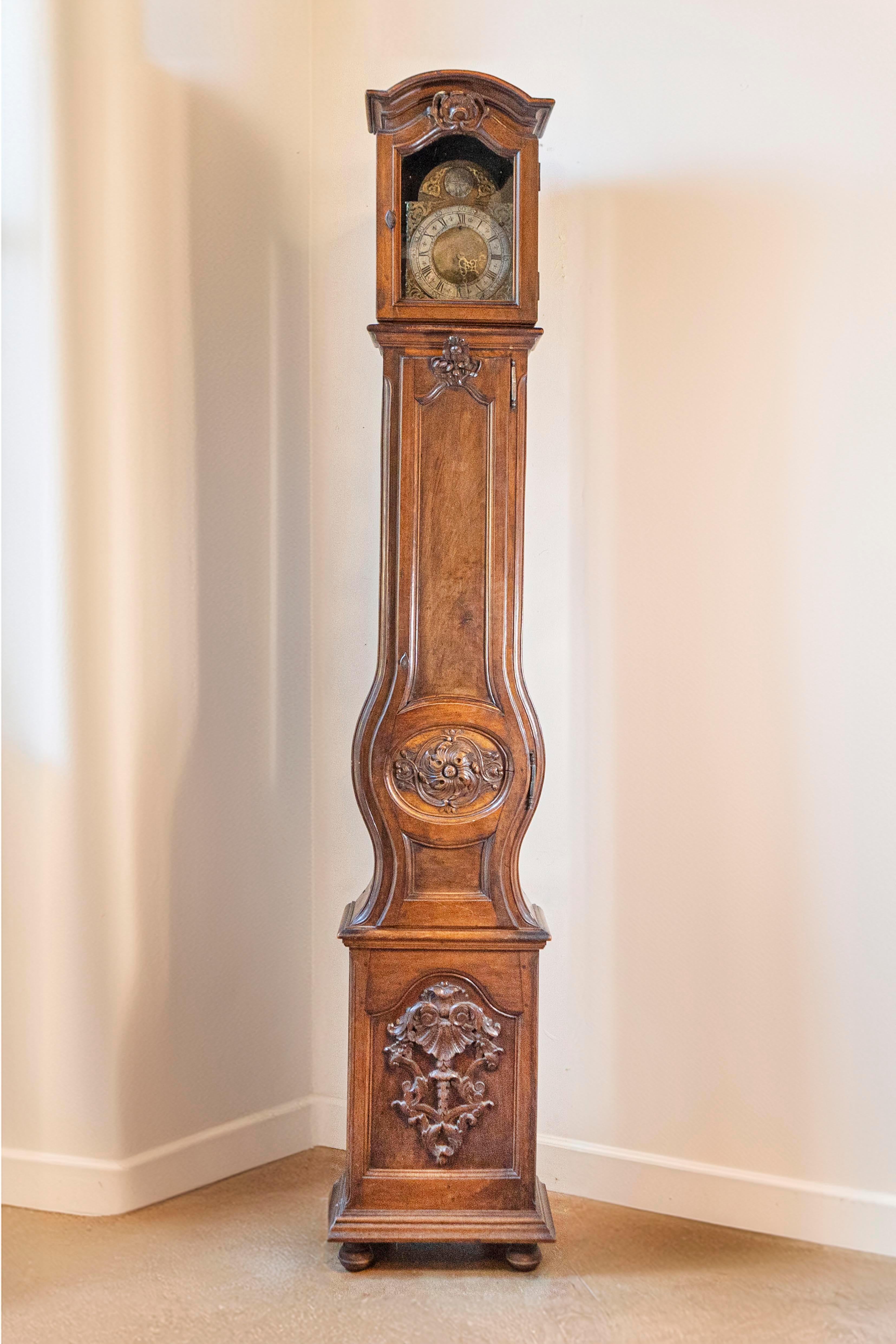 Pendule de grand-père en noyer d'époque Louis XV, du milieu du XVIIIe siècle, provenant de la vallée du Rhône. Cette haute horloge française en noyer présente une tête rectangulaire surmontée d'un fronton à bonnet surmontant un motif de Rocaille. Le