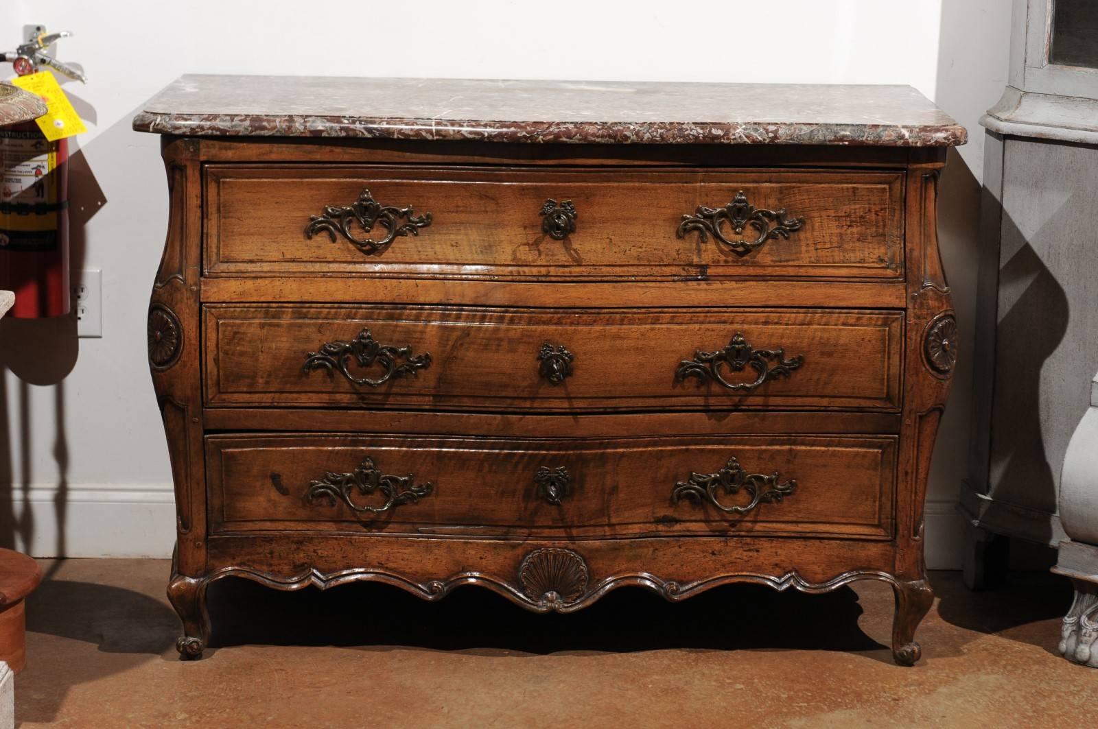 A French period Louis XV walnut Provençale three-drawer commode from the mid-18th century, with delicate serpentine front and red marble top. Born in the Southern region of Provence during the Age of Enlightenment, this exquisite French Louis XV