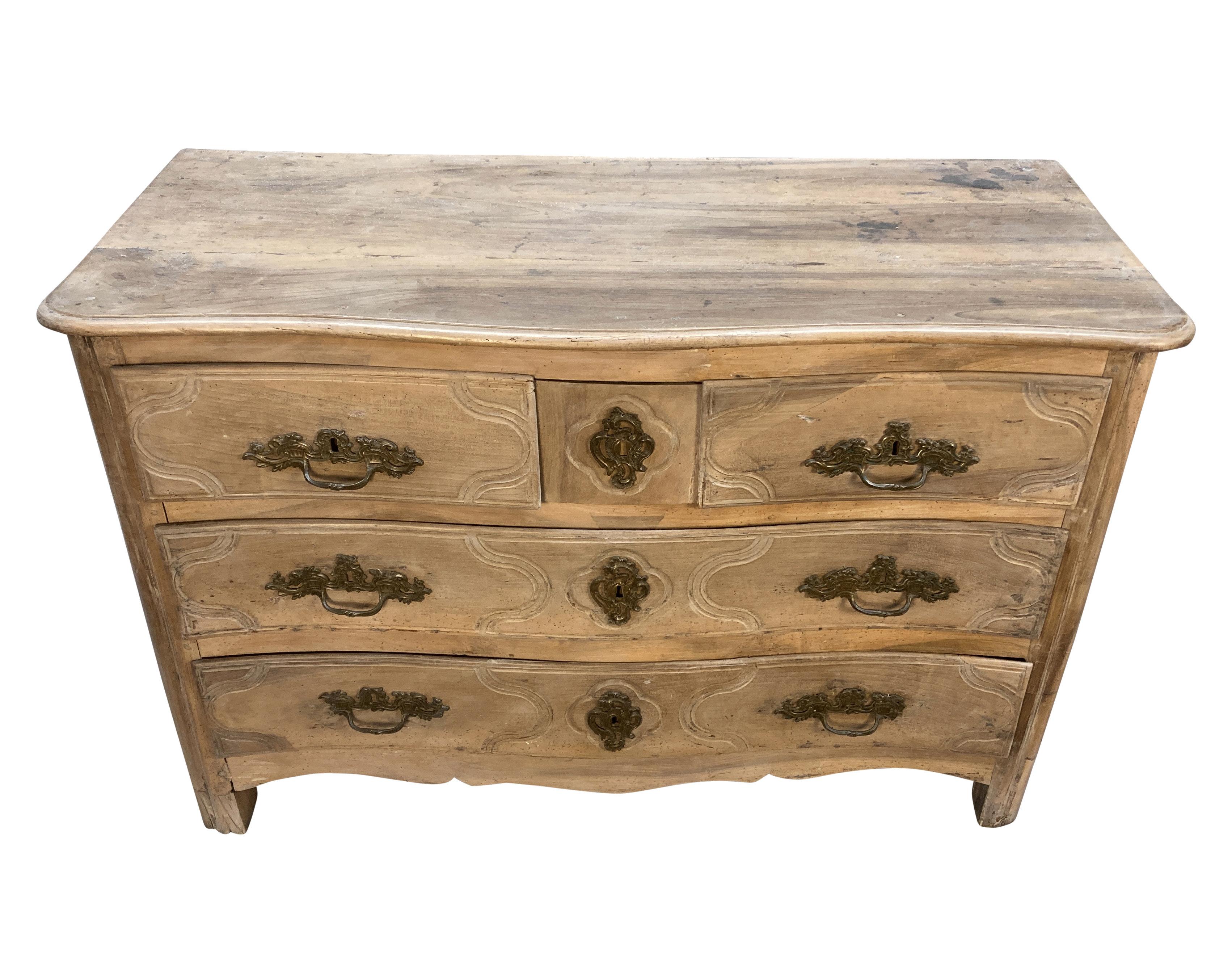 A pickled XVIII Century French Louis XV walnut commode, with serpentine front and five drawers. The original handles in bronze. Pickling was a popular trend in the 1920's-30's