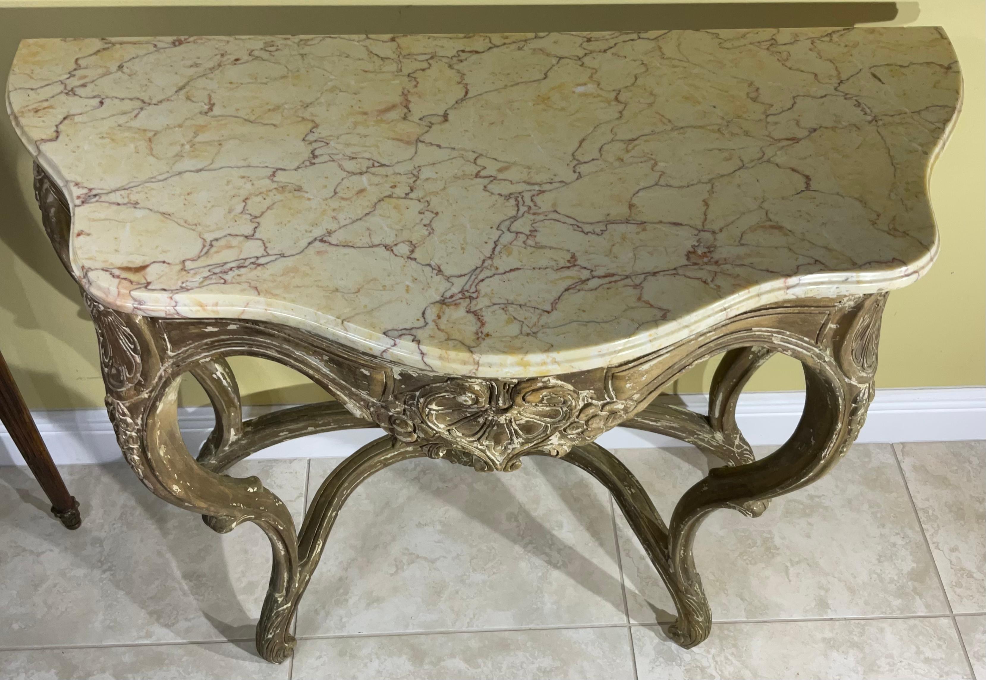 Elegant marble-top console table, artistically hand-carved wood base supported by a graceful four leg, This wall console is a beautiful example of the French Rococco style. Sculpted in curved lines and Partially painted-inspired by nature. Minor