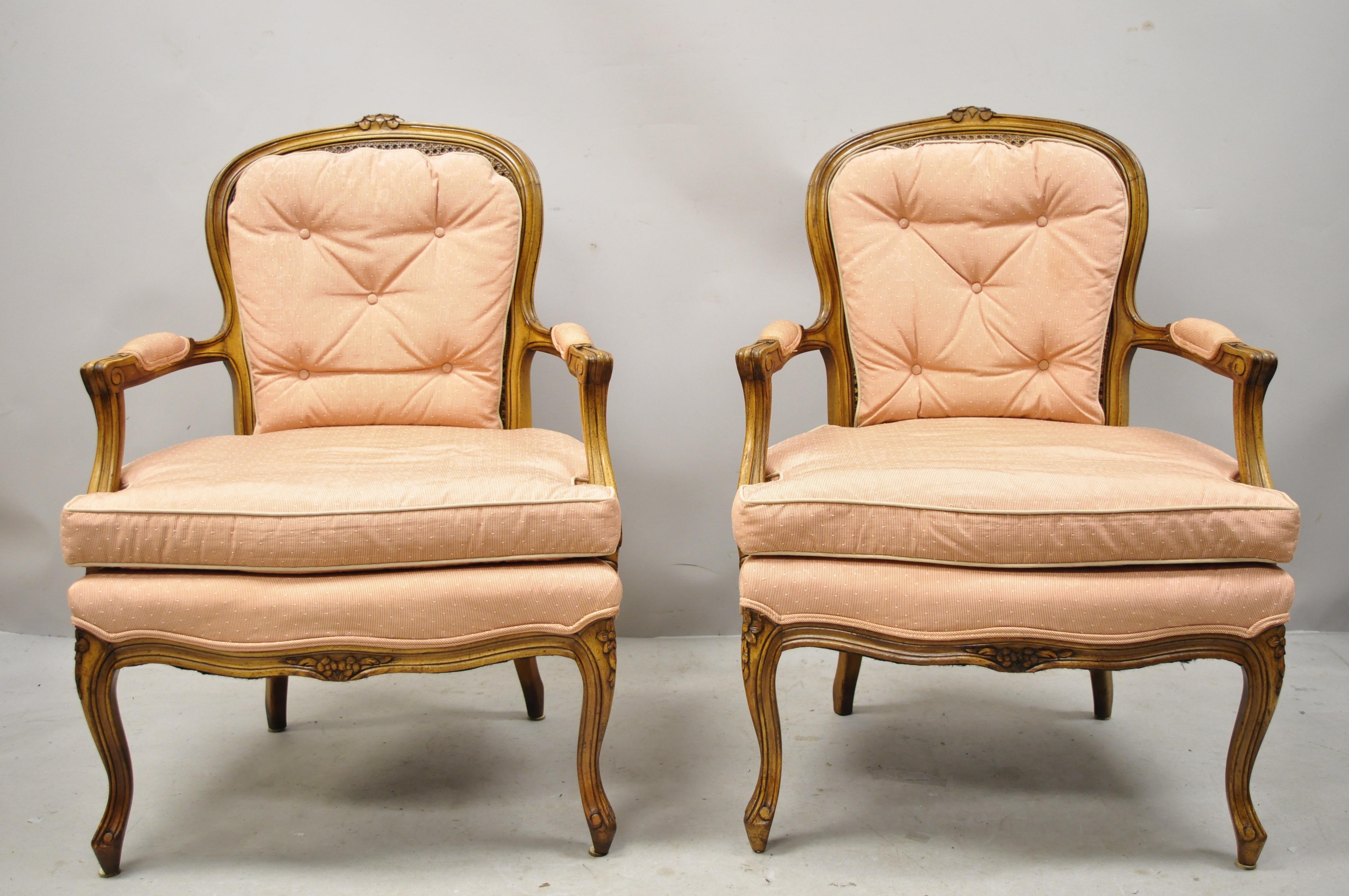 Paire de fauteuils de style provincial Louis XV français en noyer sculpté à dossier canné. L'article présente un dossier en canne, un cadre en bois massif, des accoudoirs rembourrés, des détails joliment sculptés, des pieds cabriole, un très bel