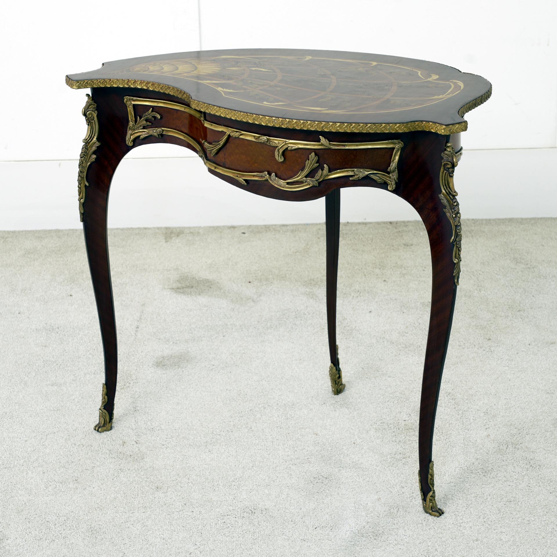 A stunning French side table in the Louis XV style, showcasing refined craftsmanship and graceful rococo curves
Bought from a dealer on Marche Biron at Paris antiques markets
The serpentine top features fine marquetry inlays depicting scrolling