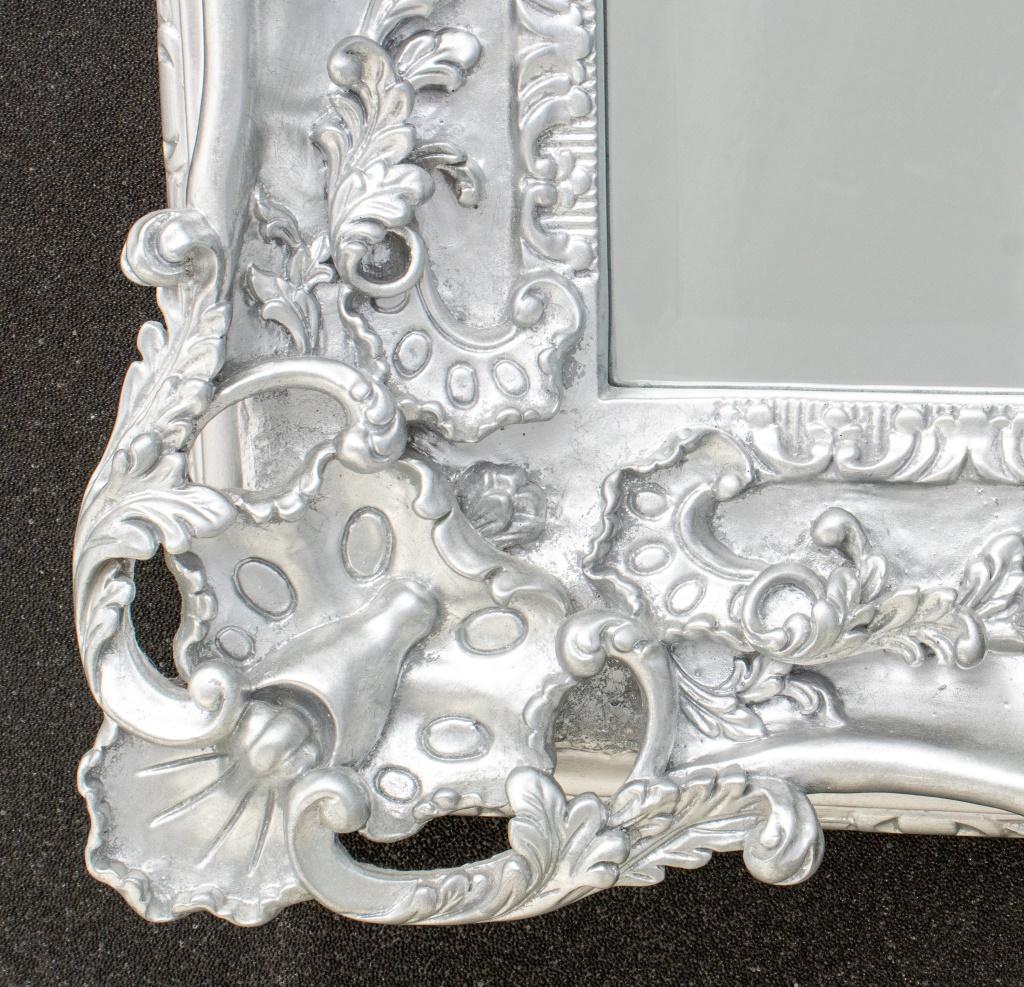 French Louis XV Rococo Style carved wood mirror in silvered tones having beveled glass. 

Dealer: S138XX.