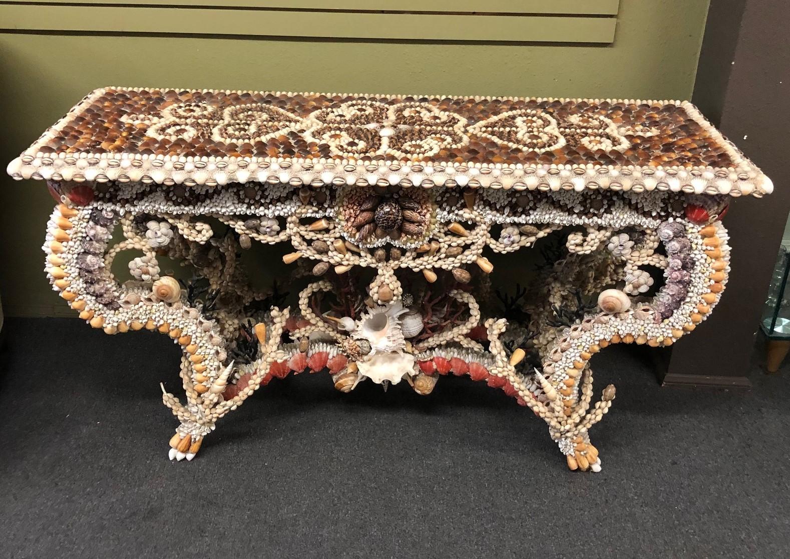 Spectacular French natural seashell encrusted console / entry table, circa 1990s. A stunning creation of natural shells and coral brings the undersea world to life in your home. Decorated throughout with shells of various sizes, designs and colors