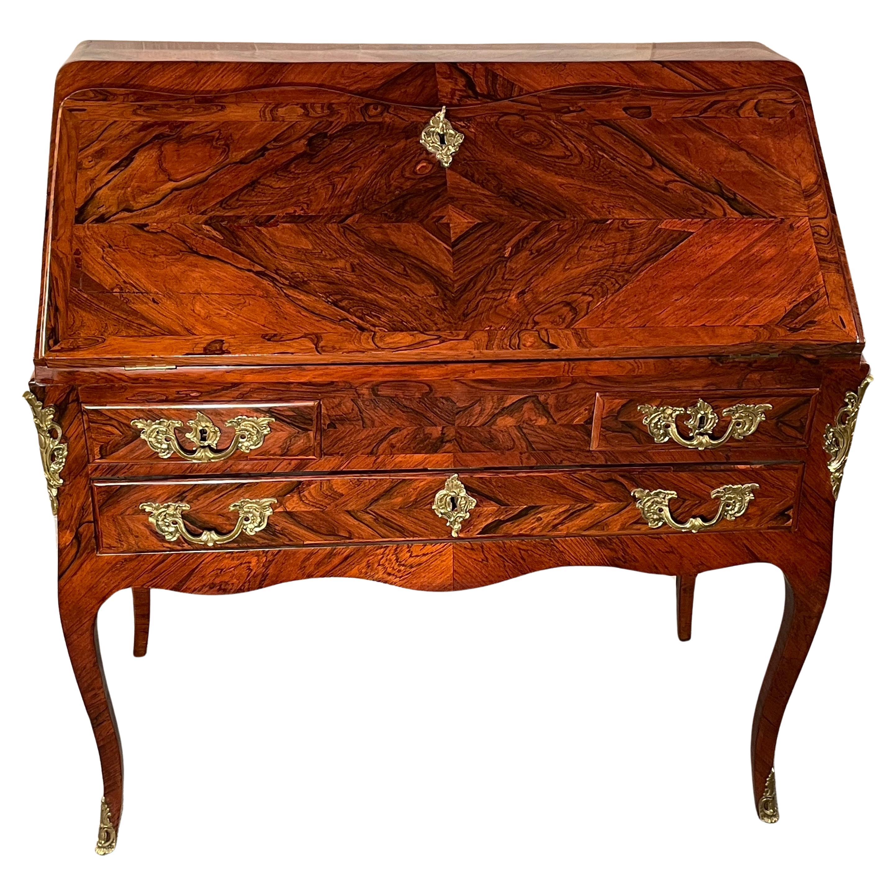 Step back in time with our exquisite 18th-century Louis XV Secretary Desk, a true masterpiece of French craftsmanship. This elegant piece of history stands gracefully on four slender legs, embodying the sophistication and charm of the Louis XV