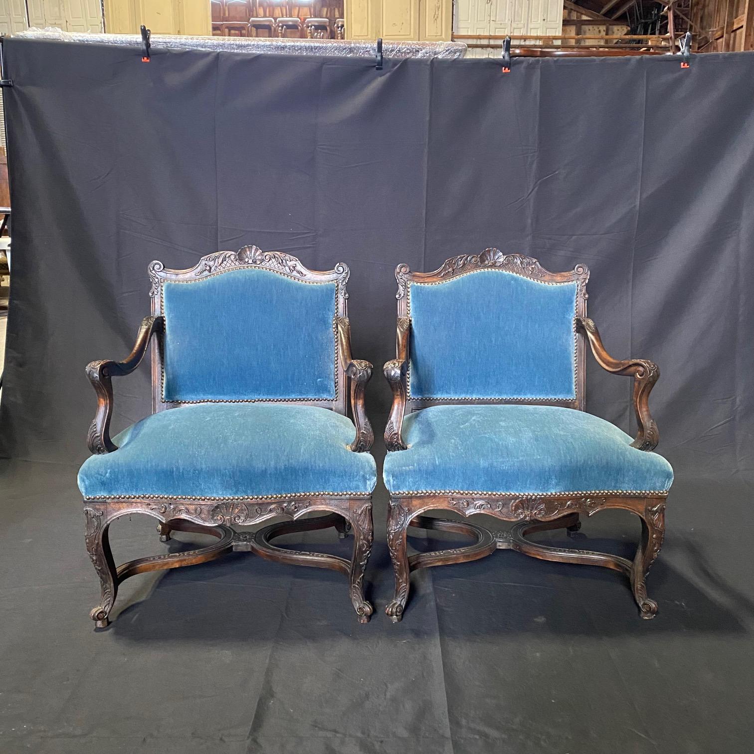  
Set of 4 antique French Louis XV chairs with stunning original blue mohair upholstery with brass tack beading, all sculpted from fine walnut, and featuring exquisitely formed frameworks with subtly arched seatback crowns and undulating aprons