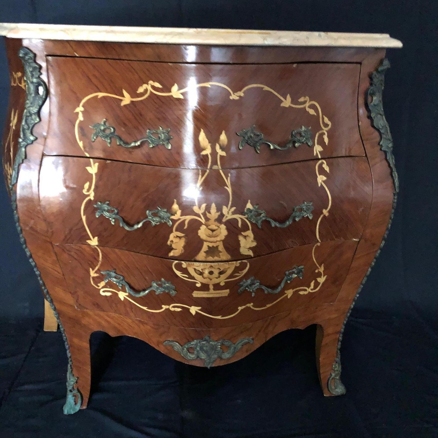 Gorgeous French Louis XV side table or nightstand with beautifully detailed inlaid floral patterns and cream marble top that coordinates with the inlays. On the front is an inlaid urn with floral decor; exquisite! Complimented by ormolu mounts,