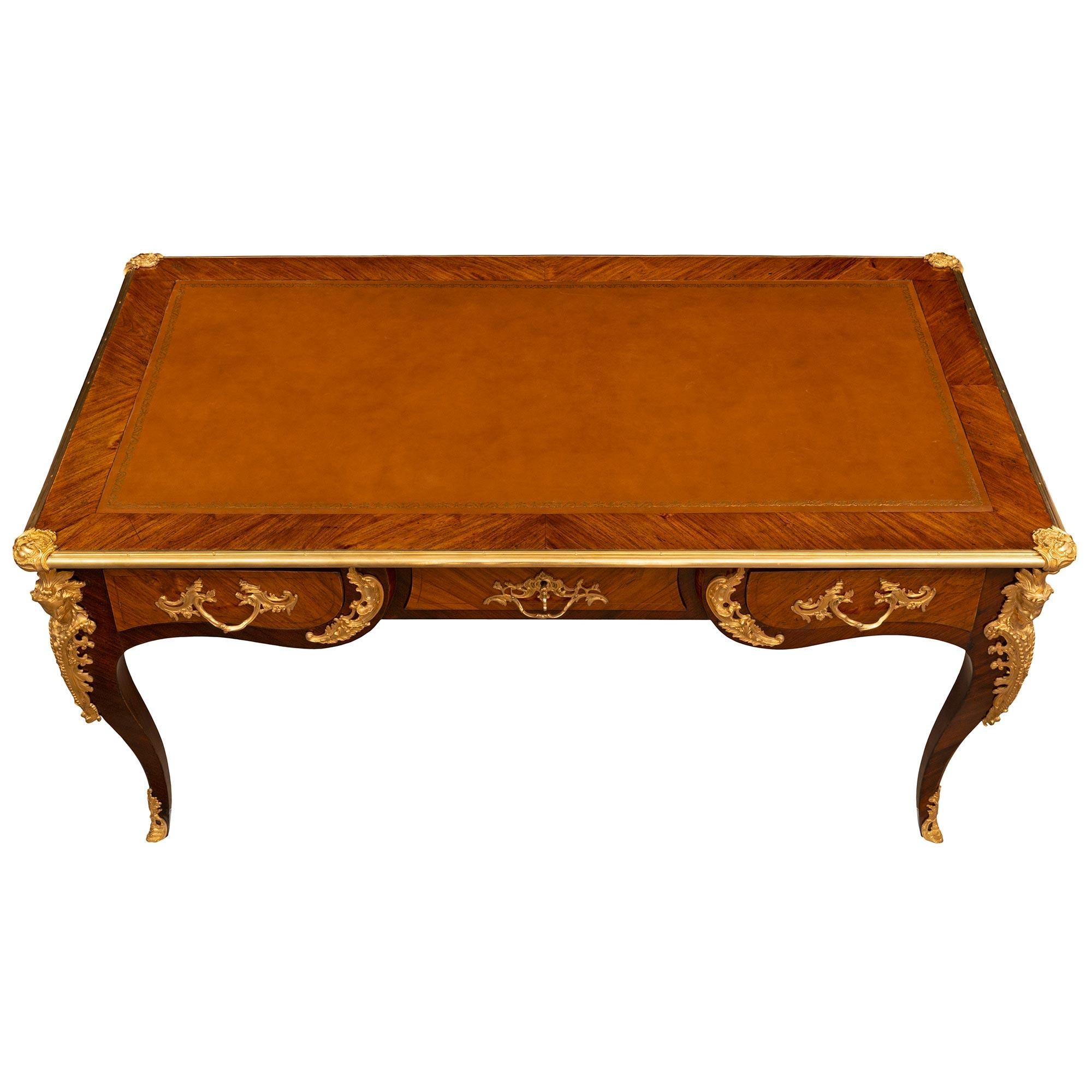 A most elegant French 19th century Louis XV st. Kingwood, Tulipwood, and ormolu partner desk/bureau plat. The six drawer desk is raised by handsome cabriole legs with striking pierced foliate ormolu sabots and impressive richly chased corner mounts