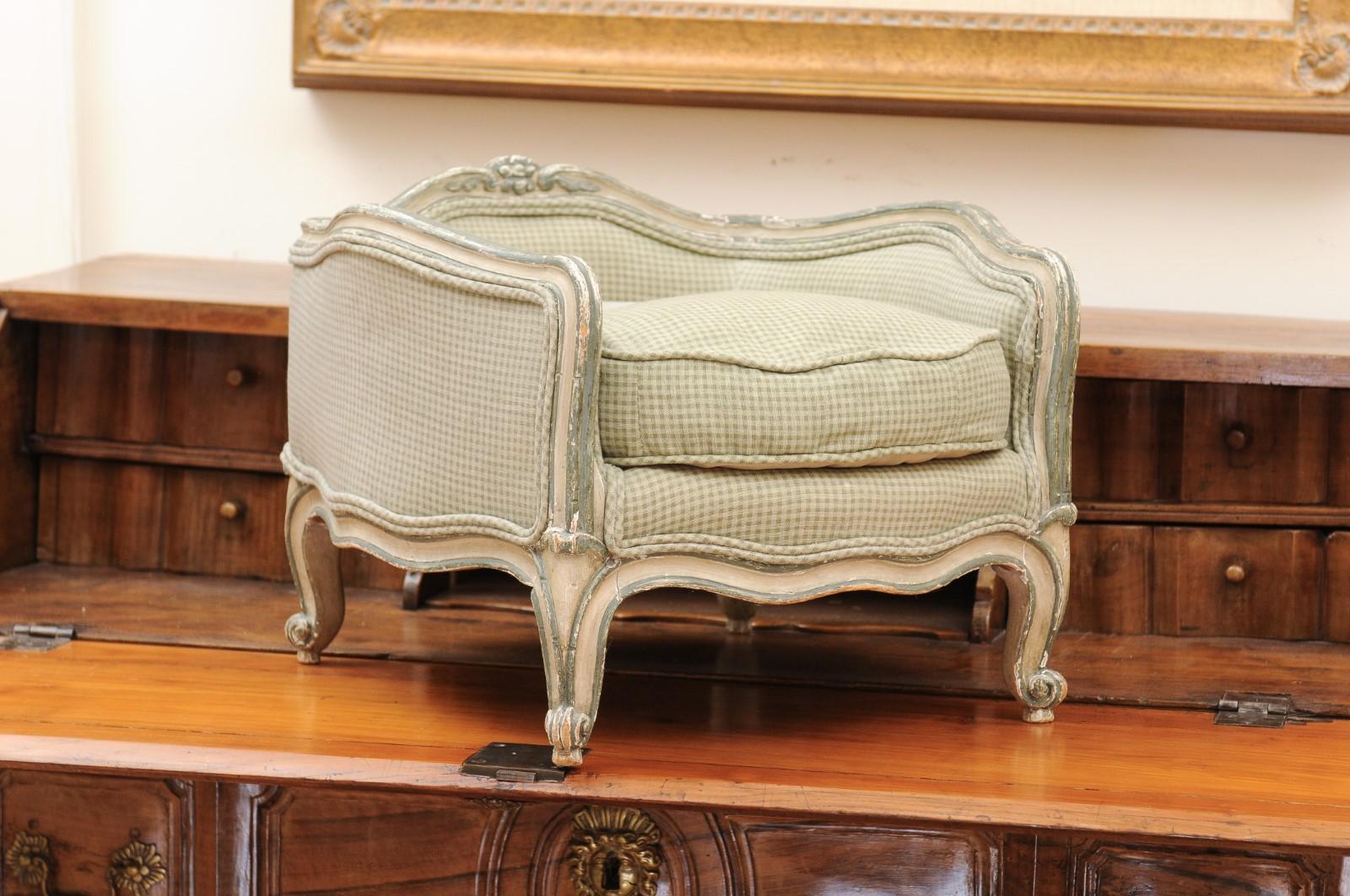 A French Louis XV style painted dog bed from the late 19th century, with cabriole legs and new upholstery. Created in France during the last quarter of the 19th century, this painted dog bed features a sinuous back topped with a carved motif,