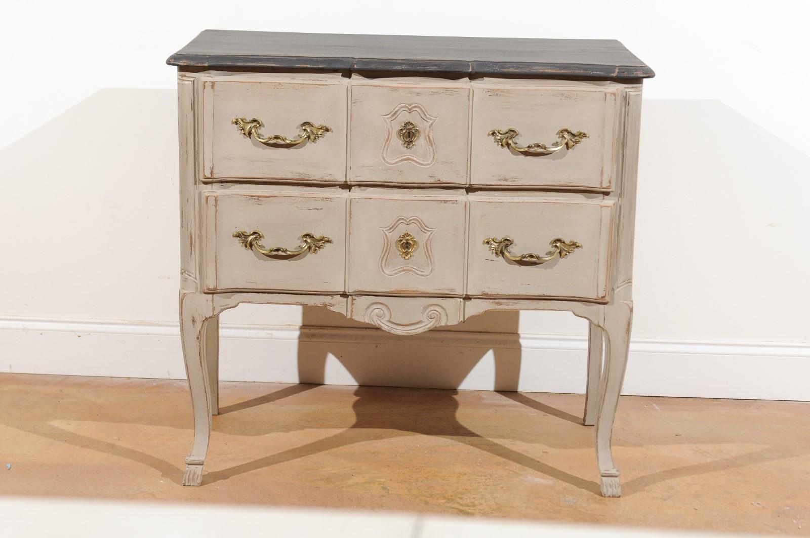 A French Louis XV style two-drawer light grey painted commode from the early 20th century, with discreet serpentine front, bronze hardware and cabriole legs. Born in the early years of the 20th century, this French commode displays the elegant