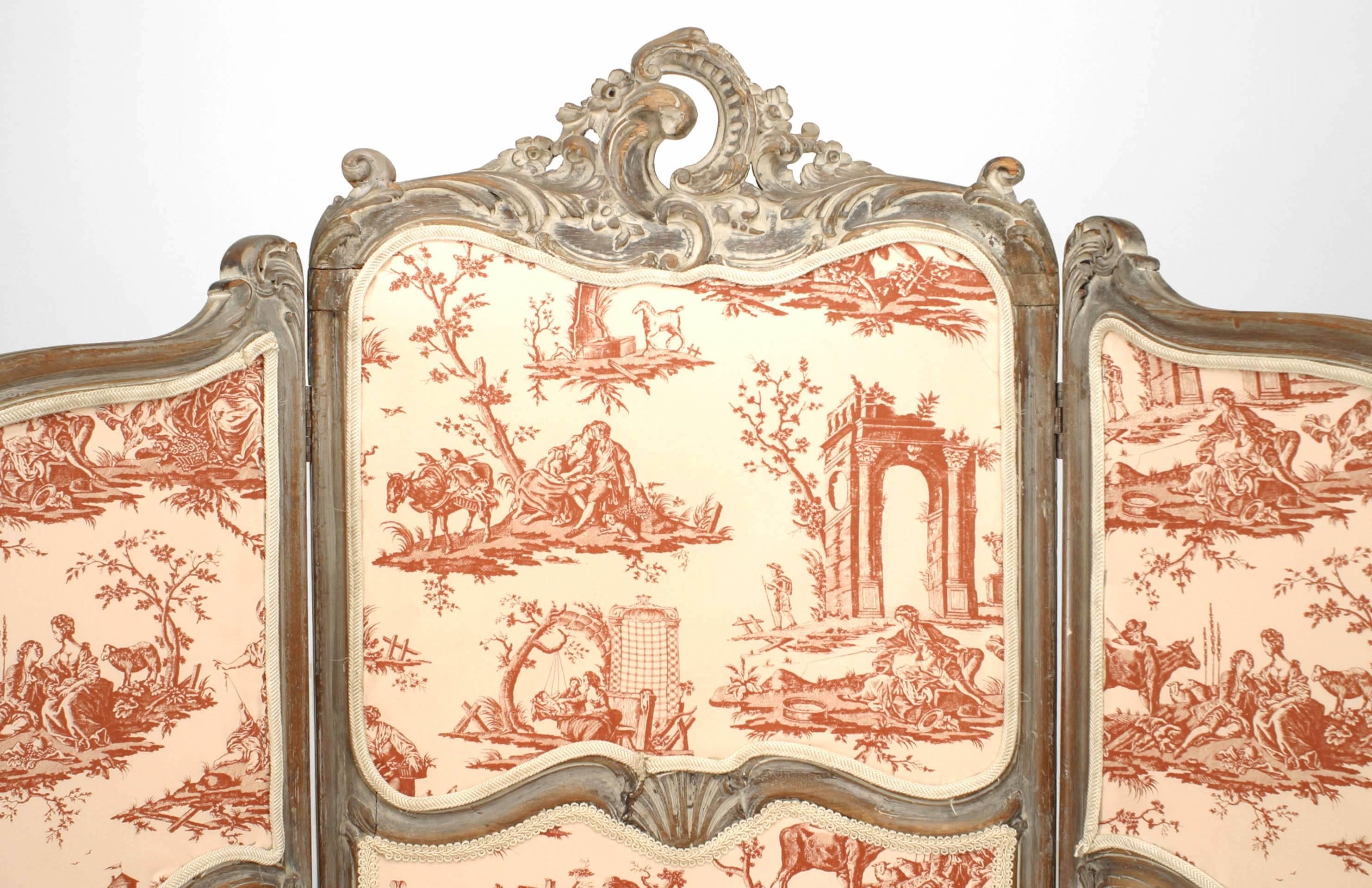 French Louis XV style (19/20th Century) cerused wooden frame 3 fold screen with white satin upholstered panels in a red toile print.
