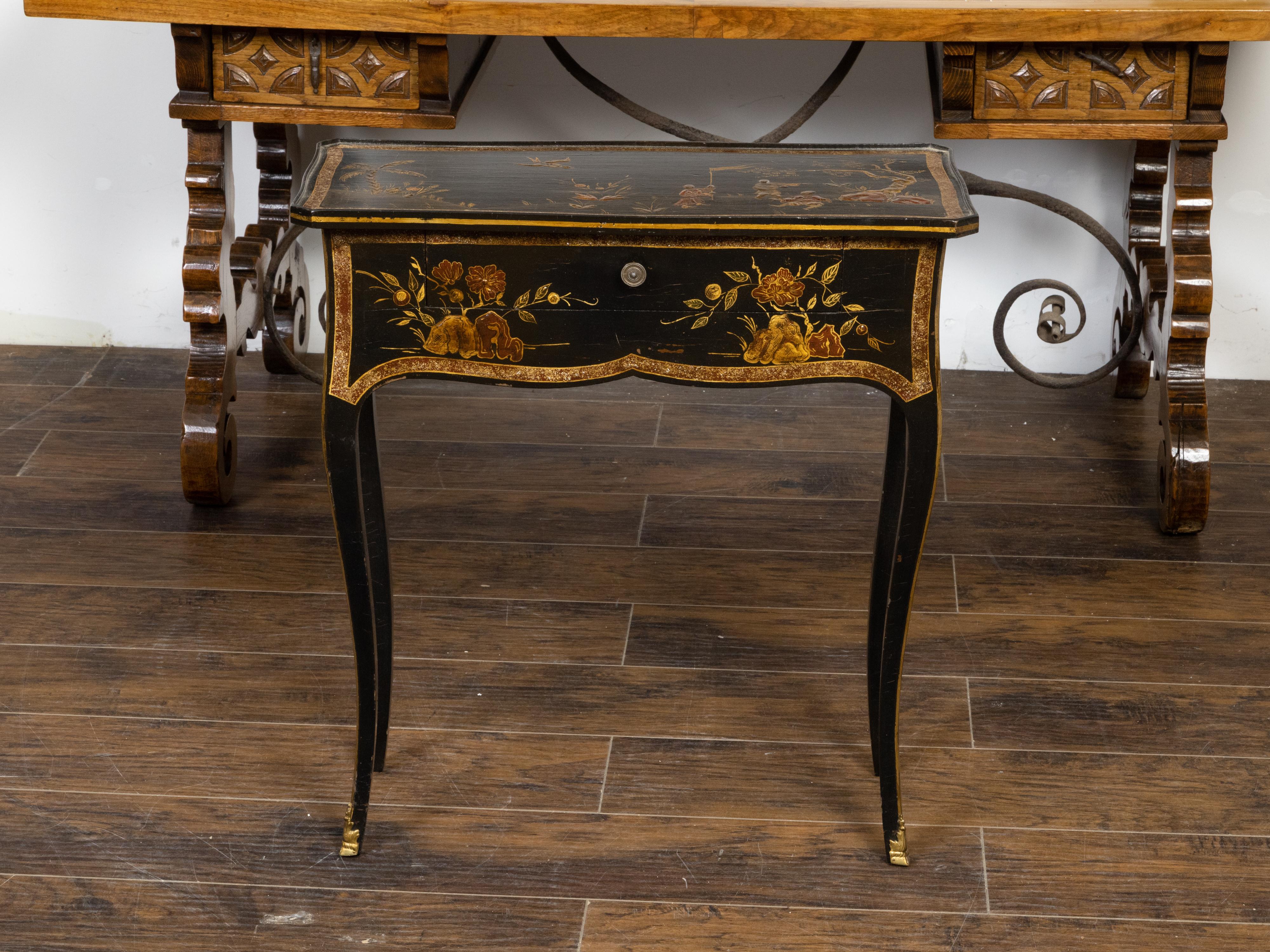 A French Louis XV style black and gold console table from the 19th century with Chinoiserie décor, single drawer and cabriole legs. Created in France during the 19th century, this console table charms us with its black and gold color, Louis XV style