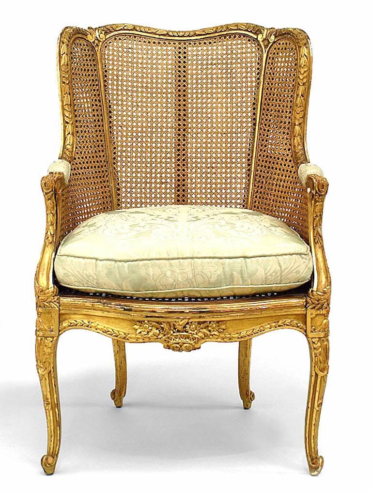 French Louis XV-style (19th Century) gilt and caned panel bergere arm chair with gold floral seat cushion
