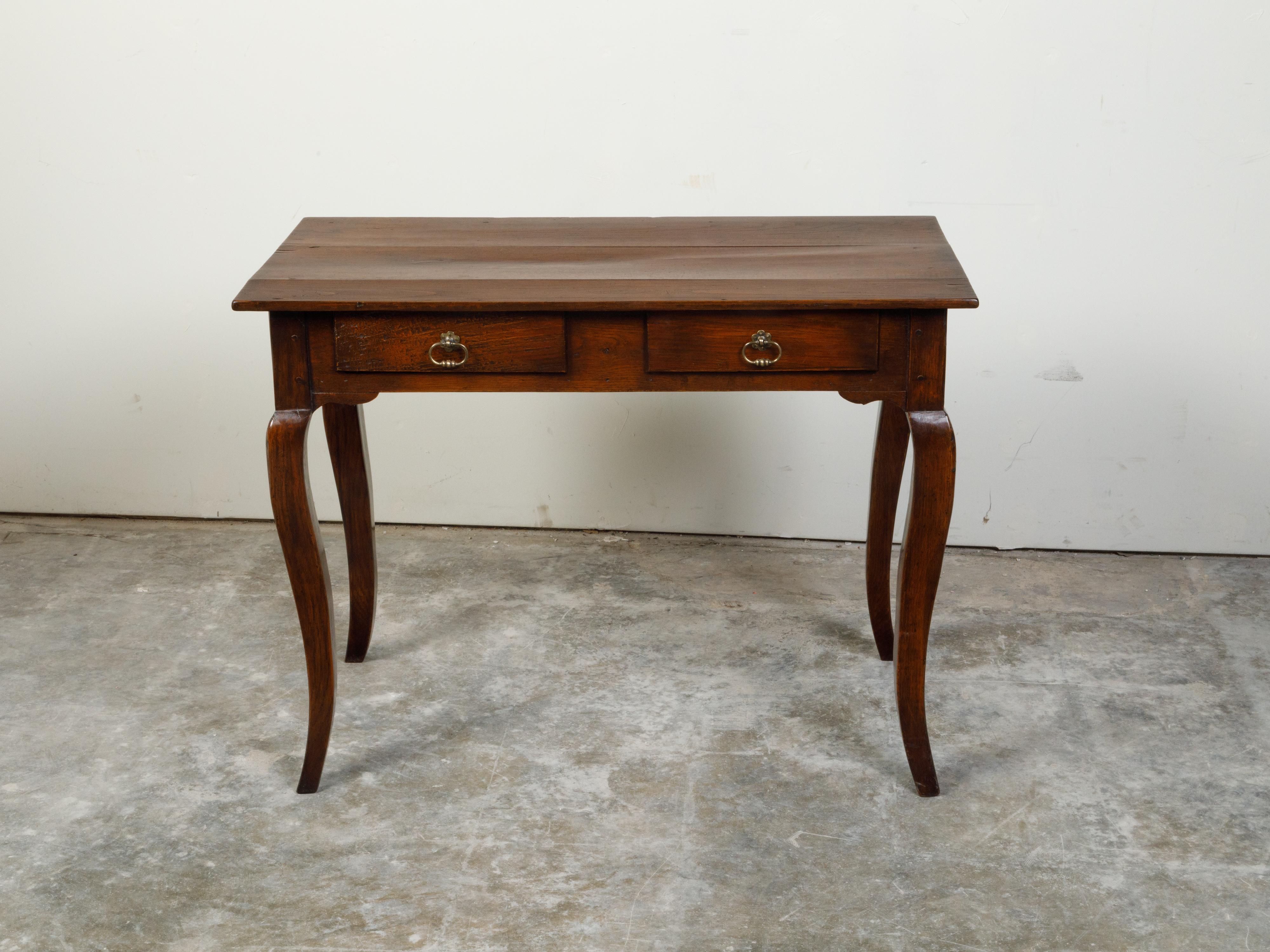 A French Louis XV style walnut desk from the 19th century, with two drawers and cabriole legs. Created in France during the 19th century, this walnut desk features a rectangular planked top sitting above two drawers fitted with bronze pulls on