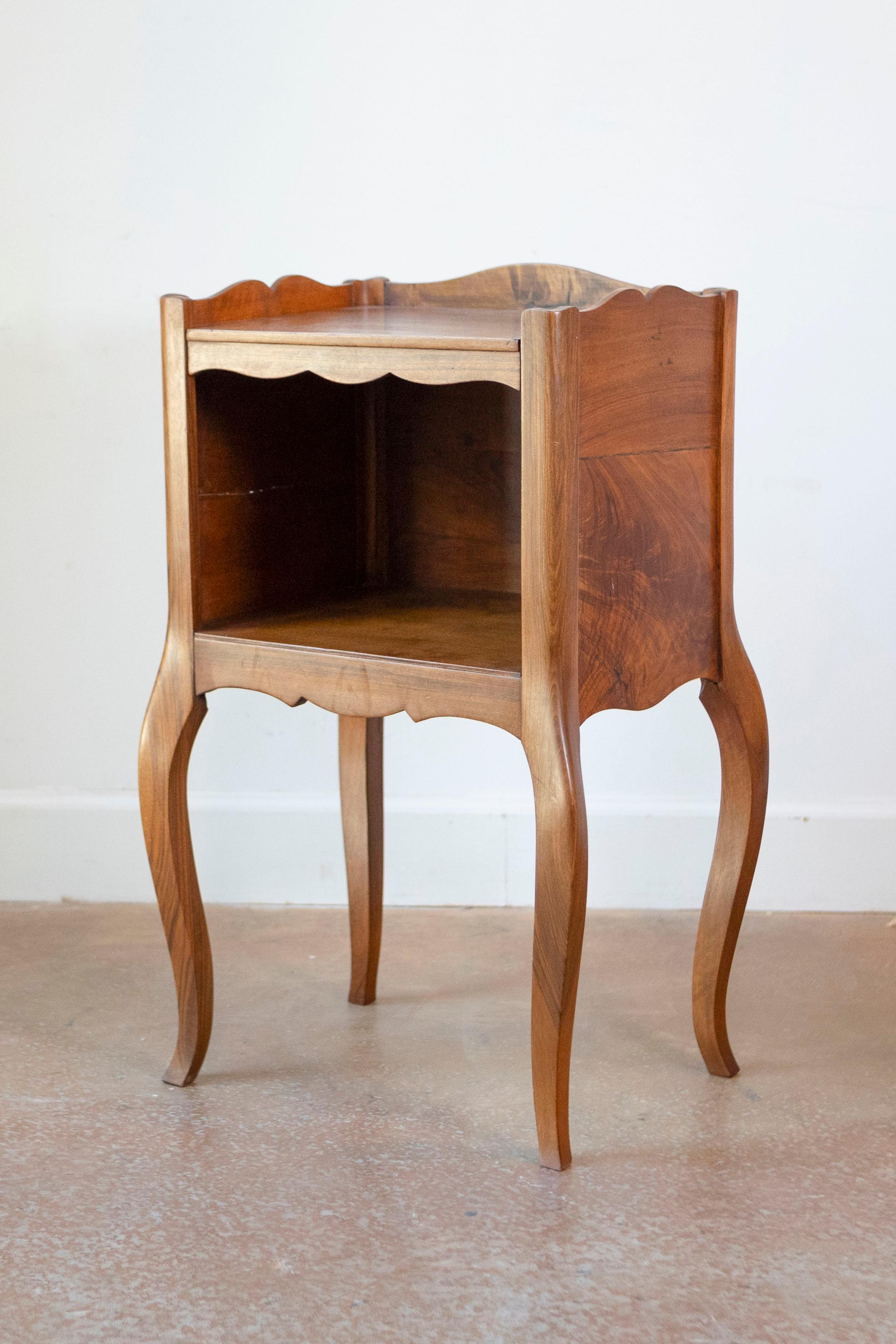 A French Louis XV style 19th century wooden bedside table with three-quarter gallery, open shelf and cabriole legs. This French Louis XV style 'table de chevet' features a rectangular top surrounded by a three-quarter gallery, sitting above an open