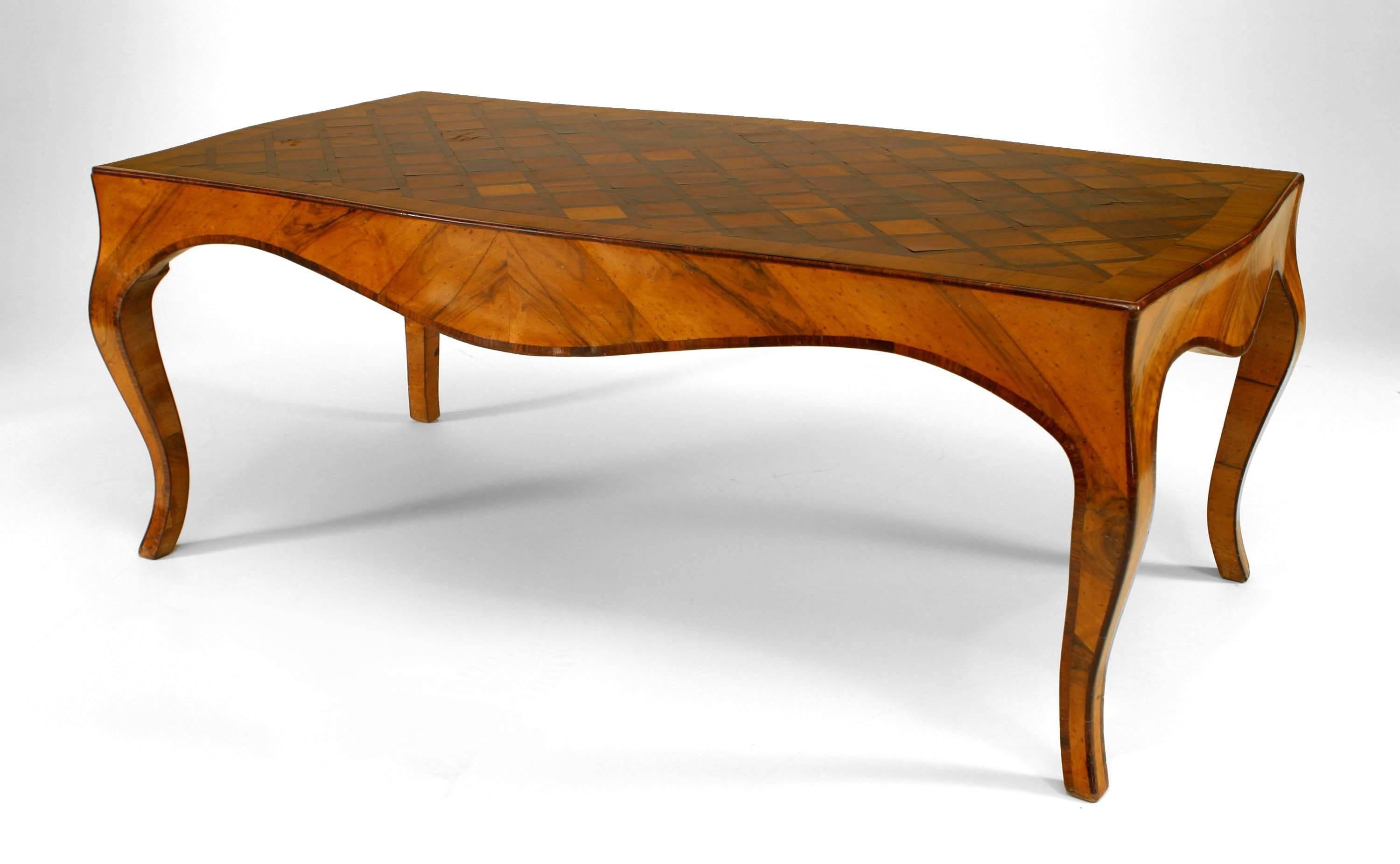 French Louis XV-style (20th Century) walnut and fruitwood coffee table with a shaped top inlaid with a parquetry design of squares.
