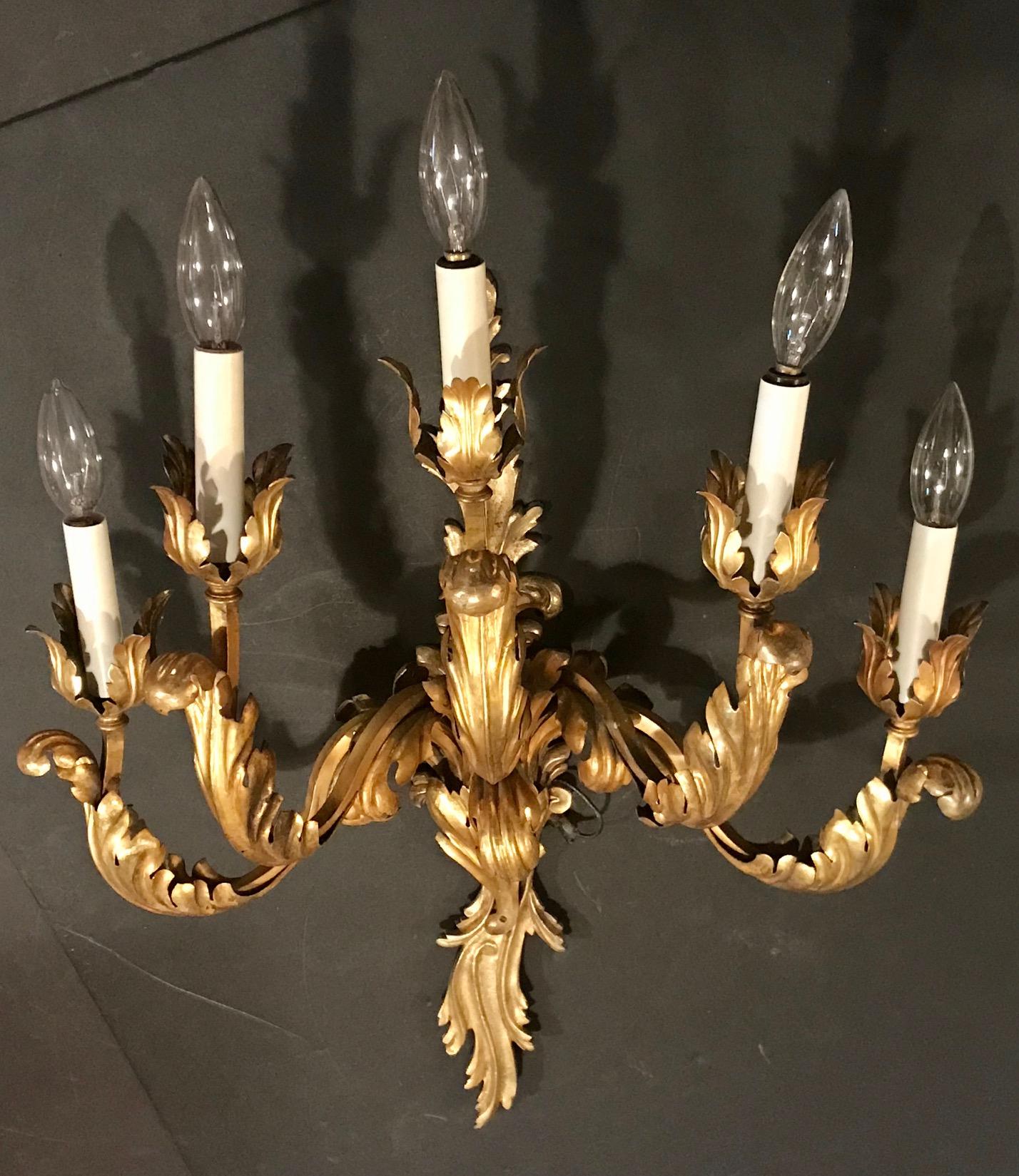 This large, electrified five-arm sconce is decoratively designed in glowing gilt bronze and metal acanthus leaves in the Louis XV style. 

The condition is very good, Lights are in working condition and the gilt is strong. The sconce is ready to