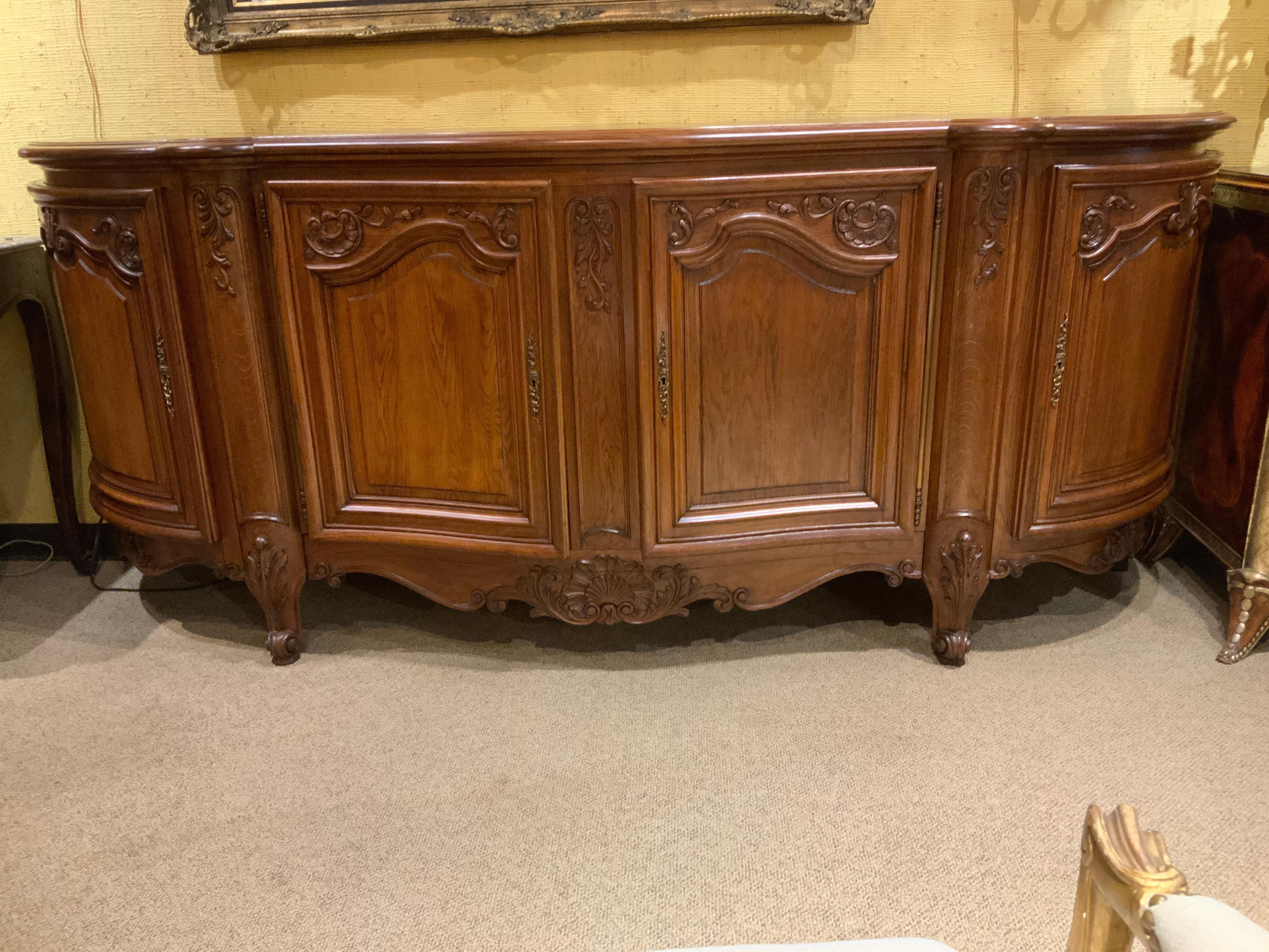 Large piece made of oak in the Louis XV-Style. Having four doors with
Great storage. The sides are gracefully curved and each side has two
Shelves. The center doors open each side has a drawer for flatware.
The legs are curved in the Louis
