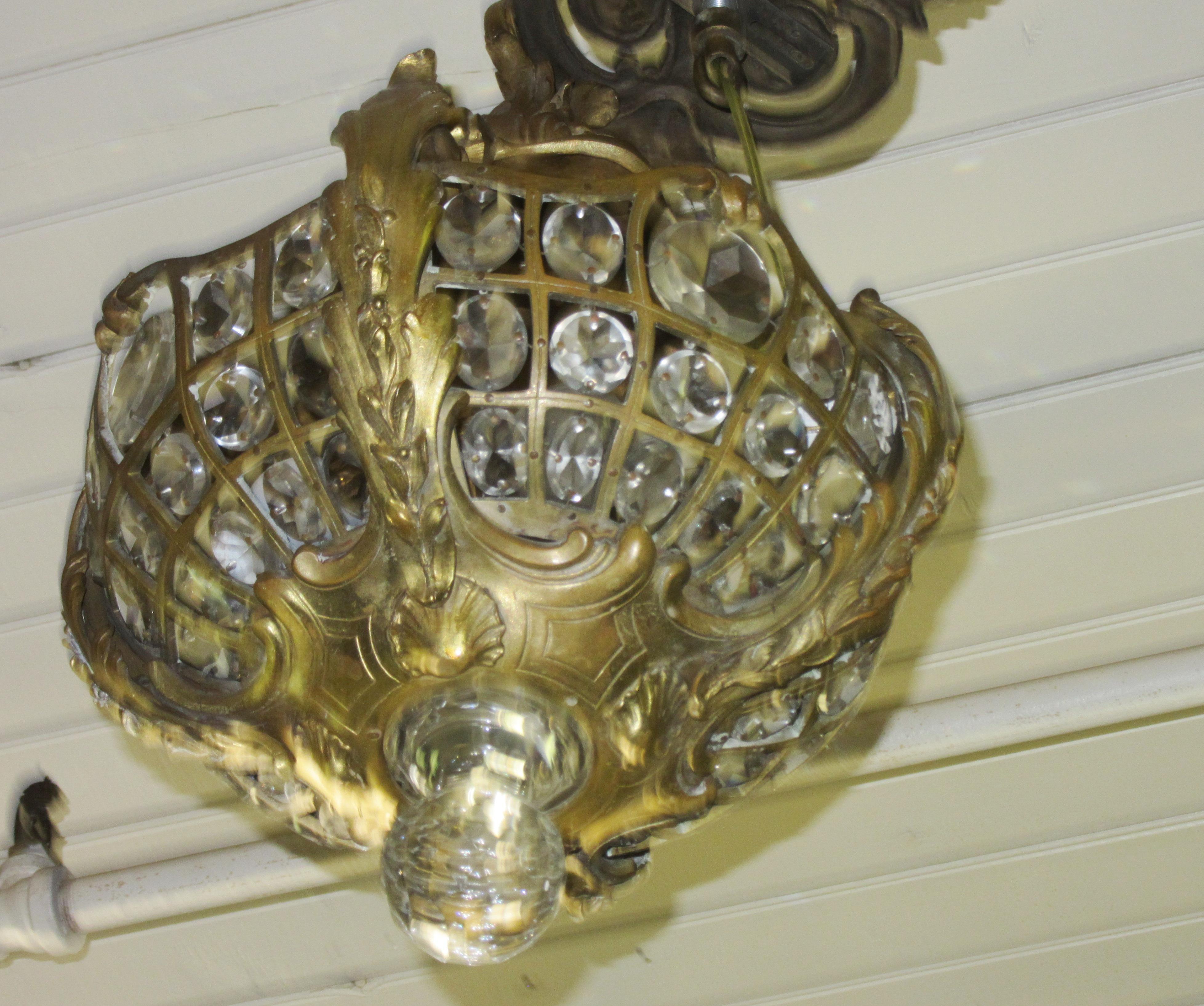 French Louis XV style gilt bronze chandelier pendant with four interior lights and cut crystal prisms. The piece was made in France during the Belle Époque of the 1900s and has been restored and rewired.
Measures: Height 20
