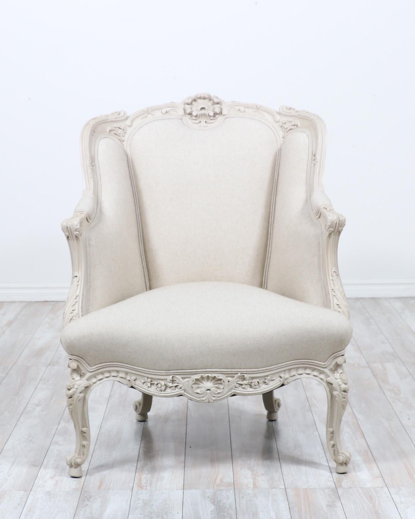 Exquisite, 1920s French painted bergère in the Louis XV style. 

The chair features delicately carved details, a fresh coat of “greige” paint with a light coat of hand applied antique glaze and new cotton linen canvas upholstery. 

Beautiful,