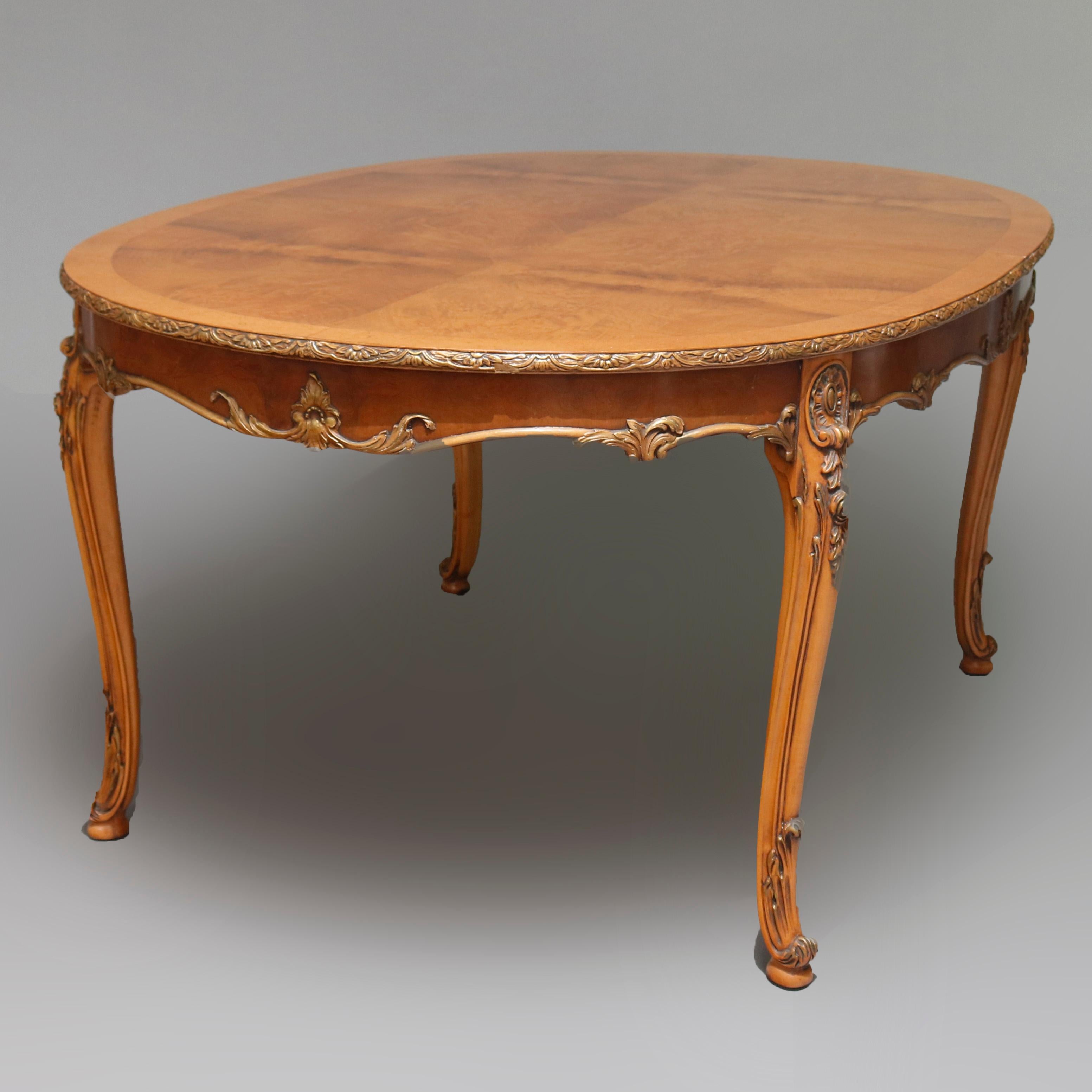 A vintage French Louis XV style dining set in Acacia by American Furniture Company offers carved maple parcel gilt table having two leaves with bookmatched bird's-eye maple top having carved and gilt foliate bordering and raised on carved foliate
