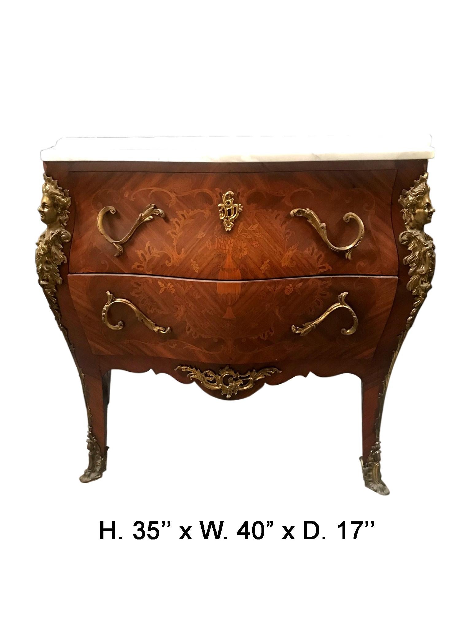 Lovely French Louis XV style bombe marquetry commode, 19th century. 
A shaped white marble top rests over two large drawers decorated in foliate motif marquetry, mounted with unique foliate decorated ormolu handles and escutcheons, each corner