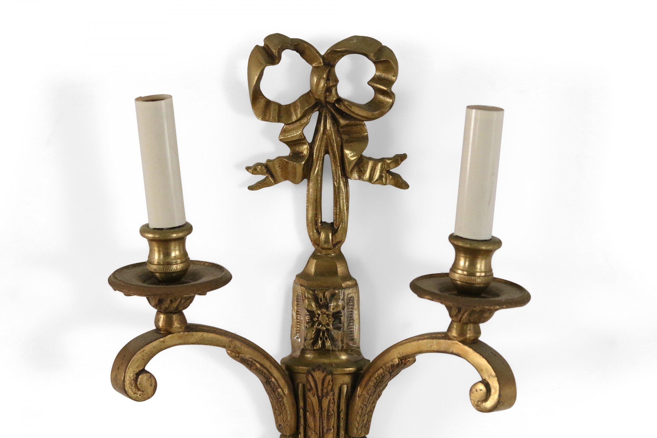 Applique da parete in stile Luigi XV (XX secolo) in bronzo dorato con nodo a fiocco e due luci elettrificate.
 