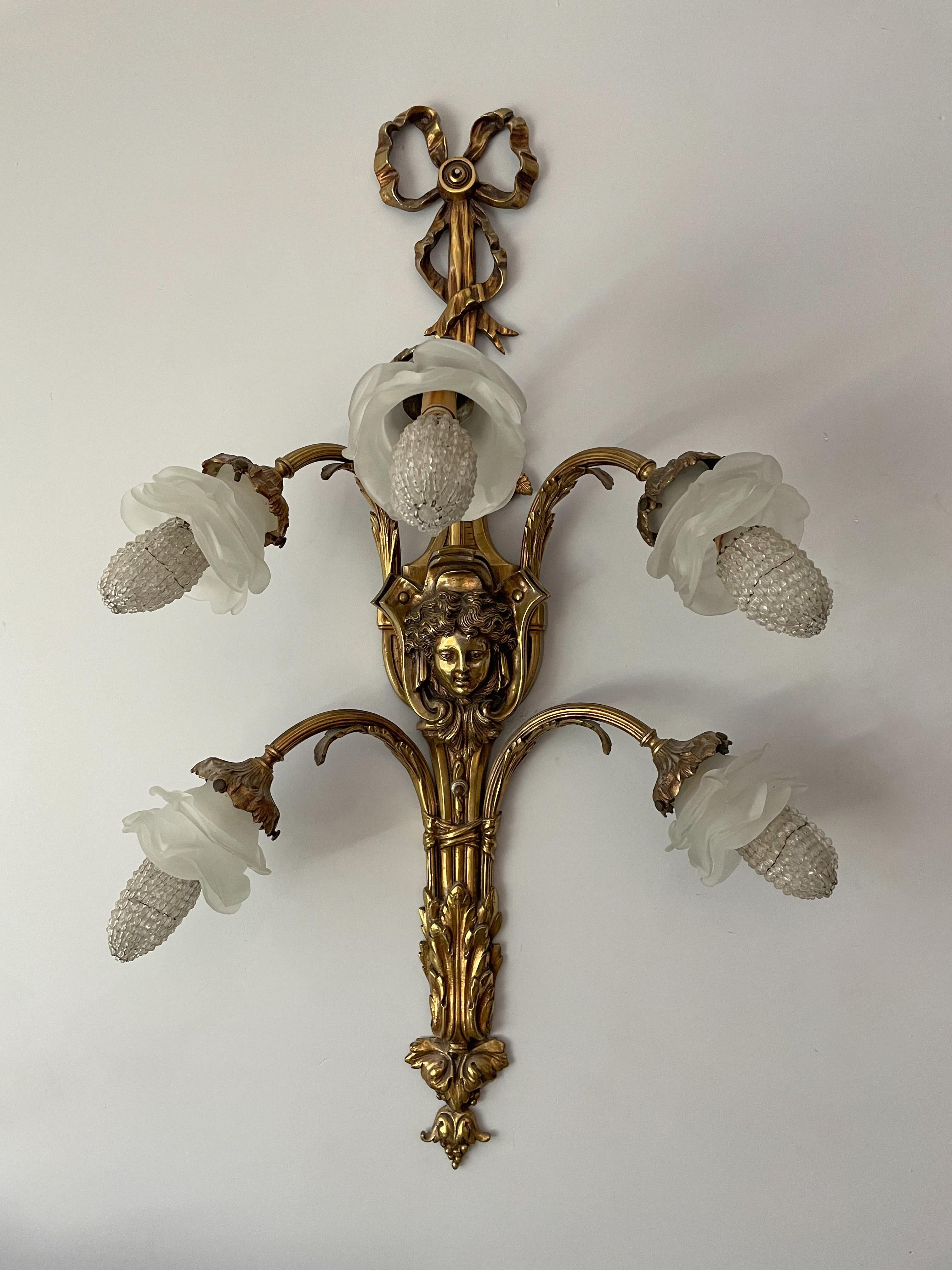 Beautiful, French Louis XV-style bronze ormolu sconce with frosted glass shades.

The sconce consists of finely detailed bronze ormolu frame with frosted glass shades in the shape of flowers. Beaded glass bulb covers are included.

The sconce is