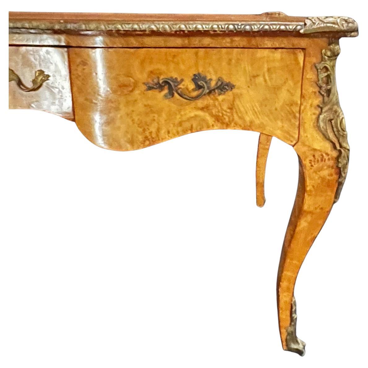 An outstanding French Louis XV style writing desk or bureau plat desk with bronze trim and ornate ormolu mounts and embossed leather top. The desk is finished on all sides and could be used floating in a room. 24.5 h over knee
#4718