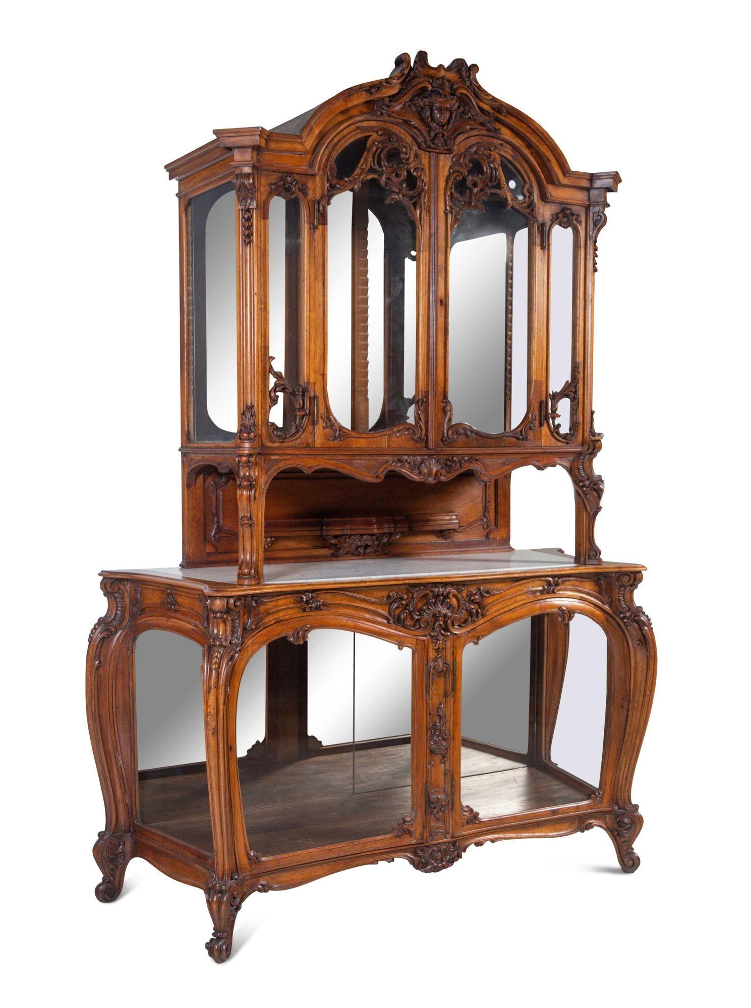 This exquisite Louis XV Style Buffet Deux Corps, made from rich walnut, features a mirrored back, adding a touch of sophistication and reflecting the beauty of the displayed objects. Its dual-cabinet design, with upper and lower compartments, allows