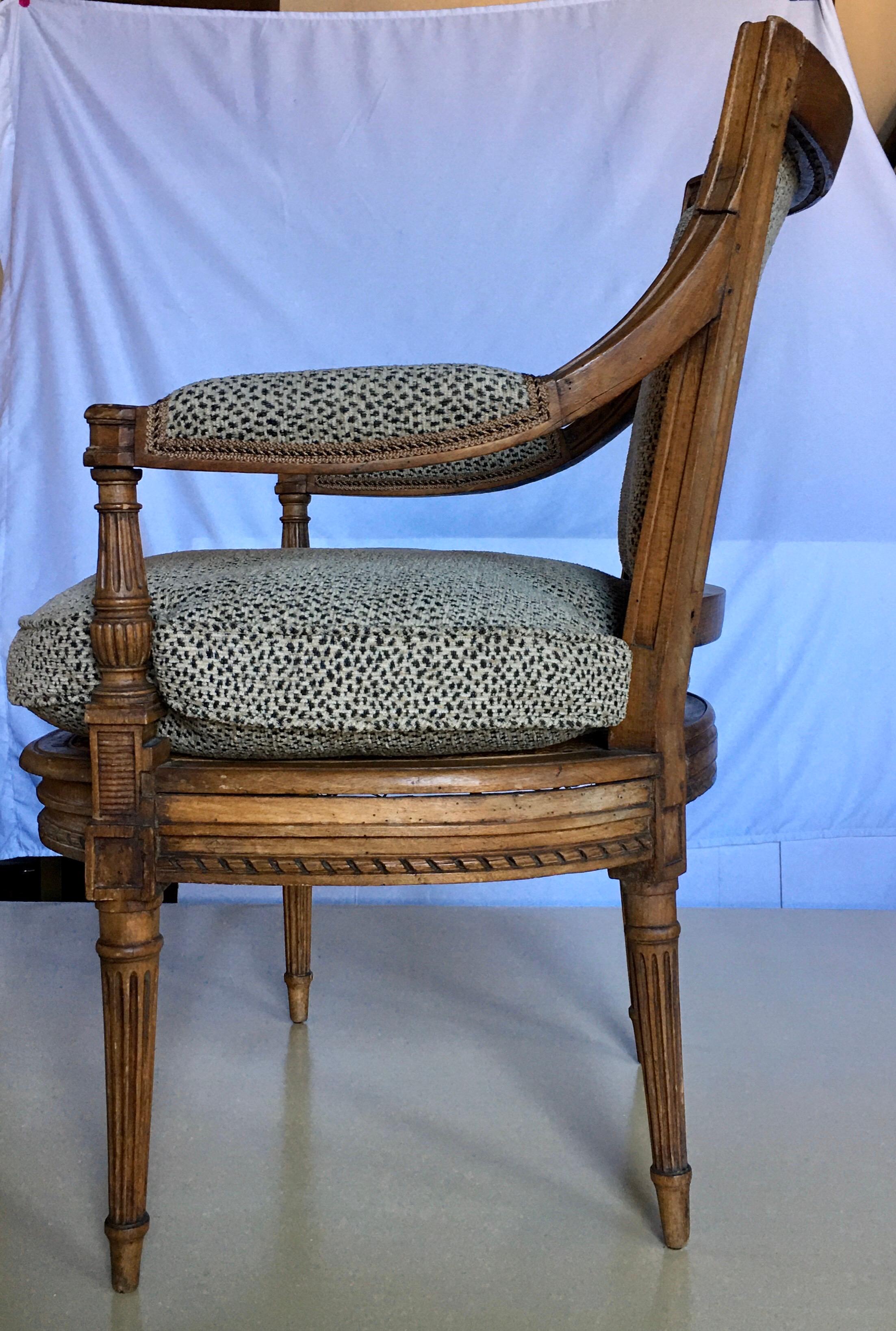 French Louis XV style cane seat accent armchair with upholstered arm and back and loose feather down stuffed seat cushion. Newly reupholstered in an animal print fabric by Kravet. This beautifully carved wood Fauteuil chair was restored in 1955 by a
