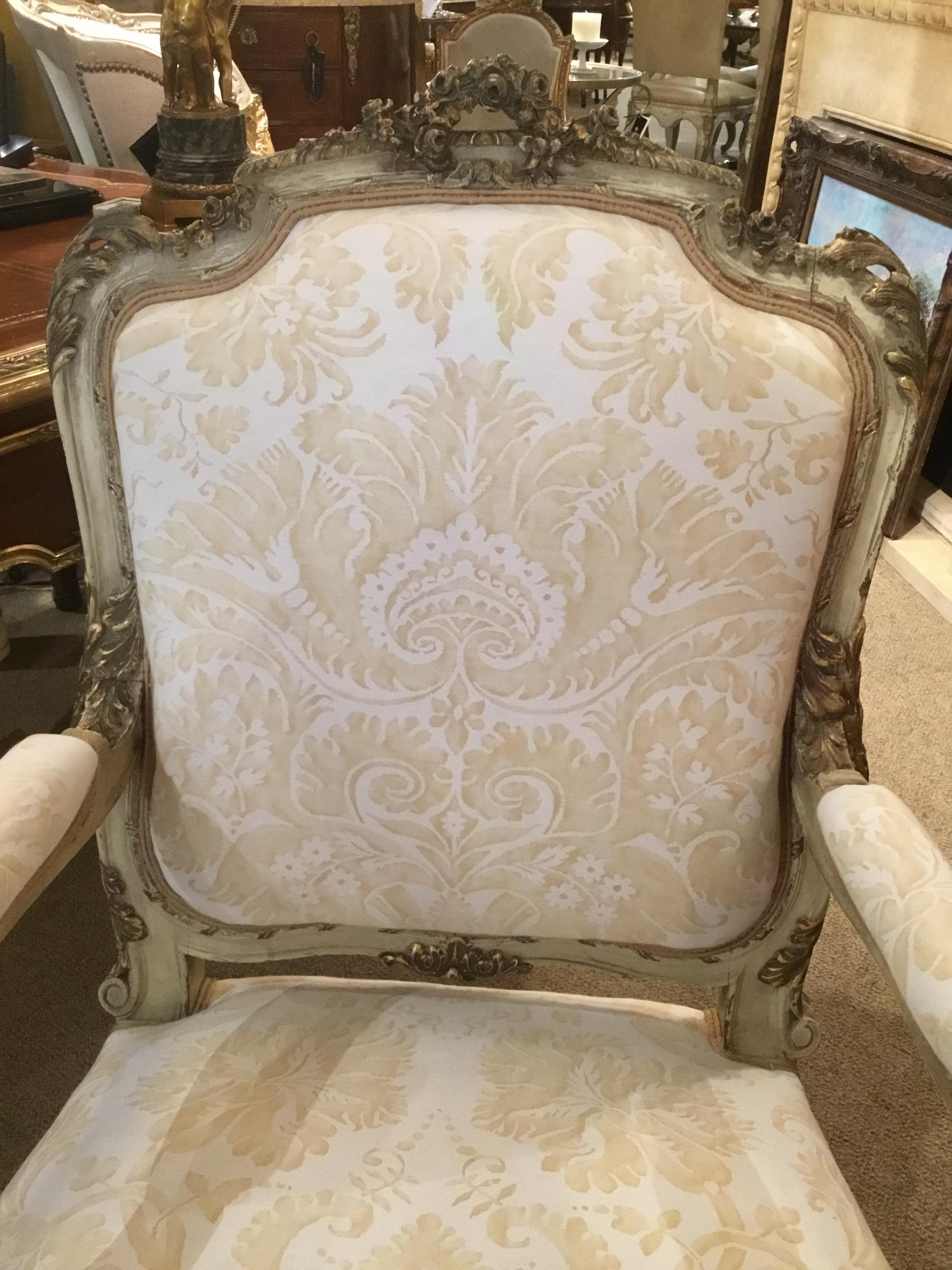 Parcel paint and parcel giltwood carved 19th century armchair or fauteuils
Upholstered in new Fortuny fabric. The finish is in antique condition,
With lovely shades of cream paint and highlights of gold gilt. A crest of
Flowers is centered at the