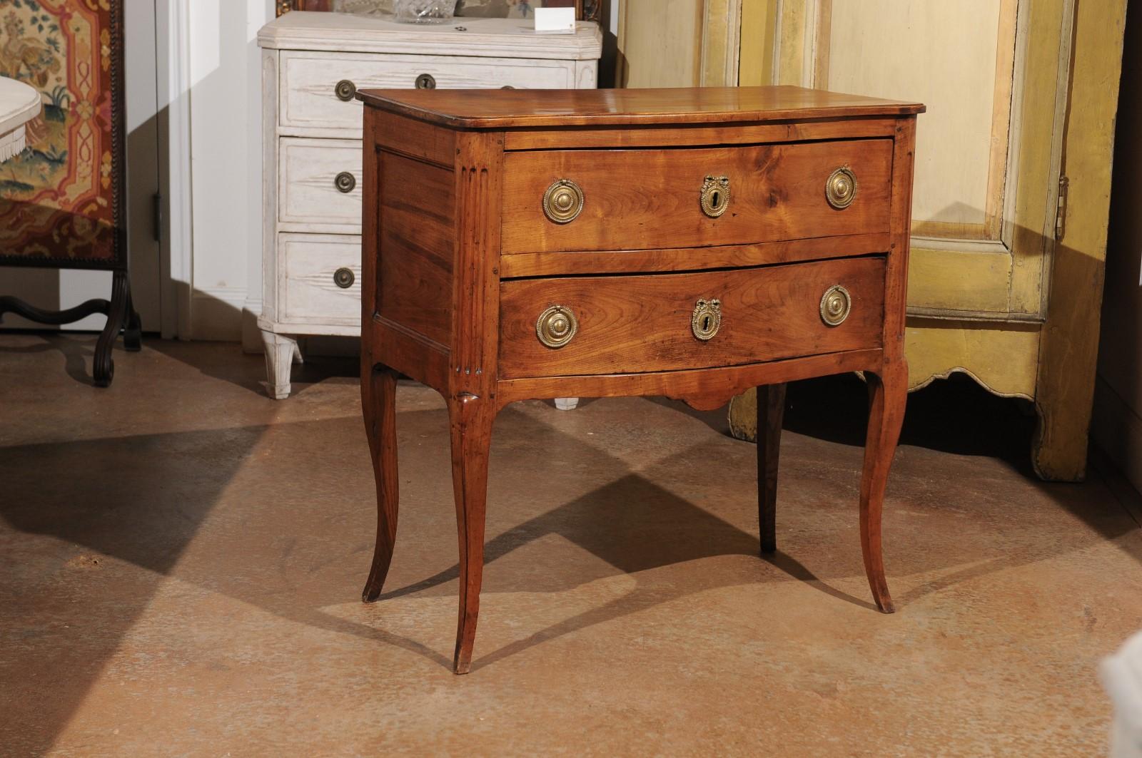 A French Louis XV style cherry commode from the mid-19th century, with two drawers and cabriole legs. Born in France at the end of the Restauration period, this lovely commode presents the stylistic characteristics of the Louis XV era. This piece