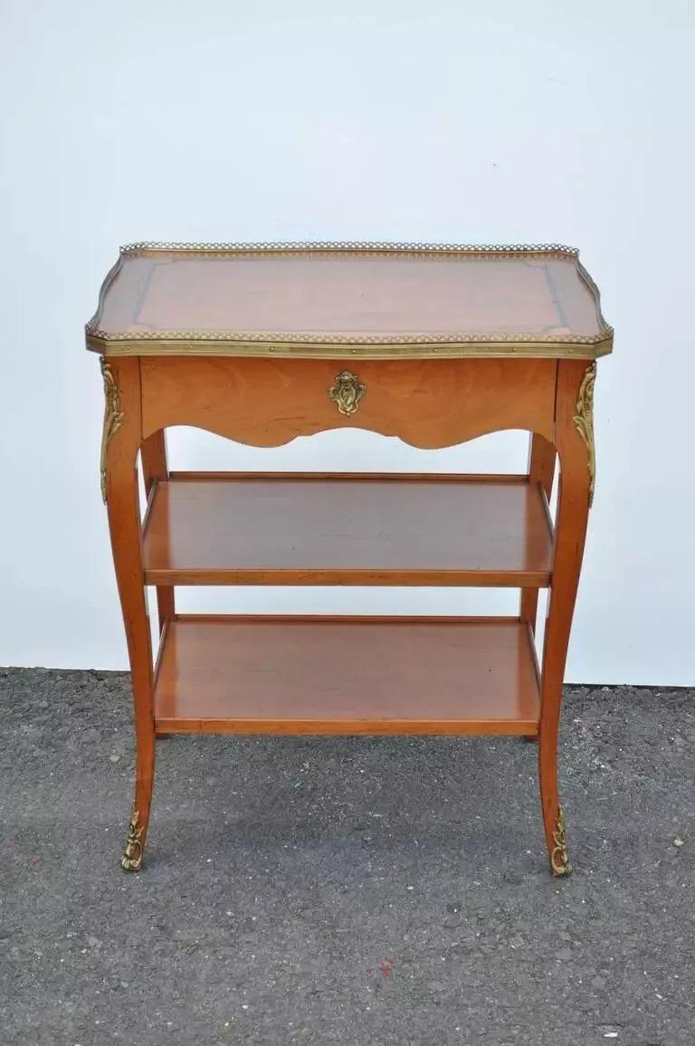 Tavolino con lampada a un cassetto in legno di ciliegio in stile Luigi XV con ornamento in bronzo. L'articolo è costruito in ciliegio massiccio con un unico cassetto a coda di rondine, un piano intarsiato, giunture a perno a vista, schienale