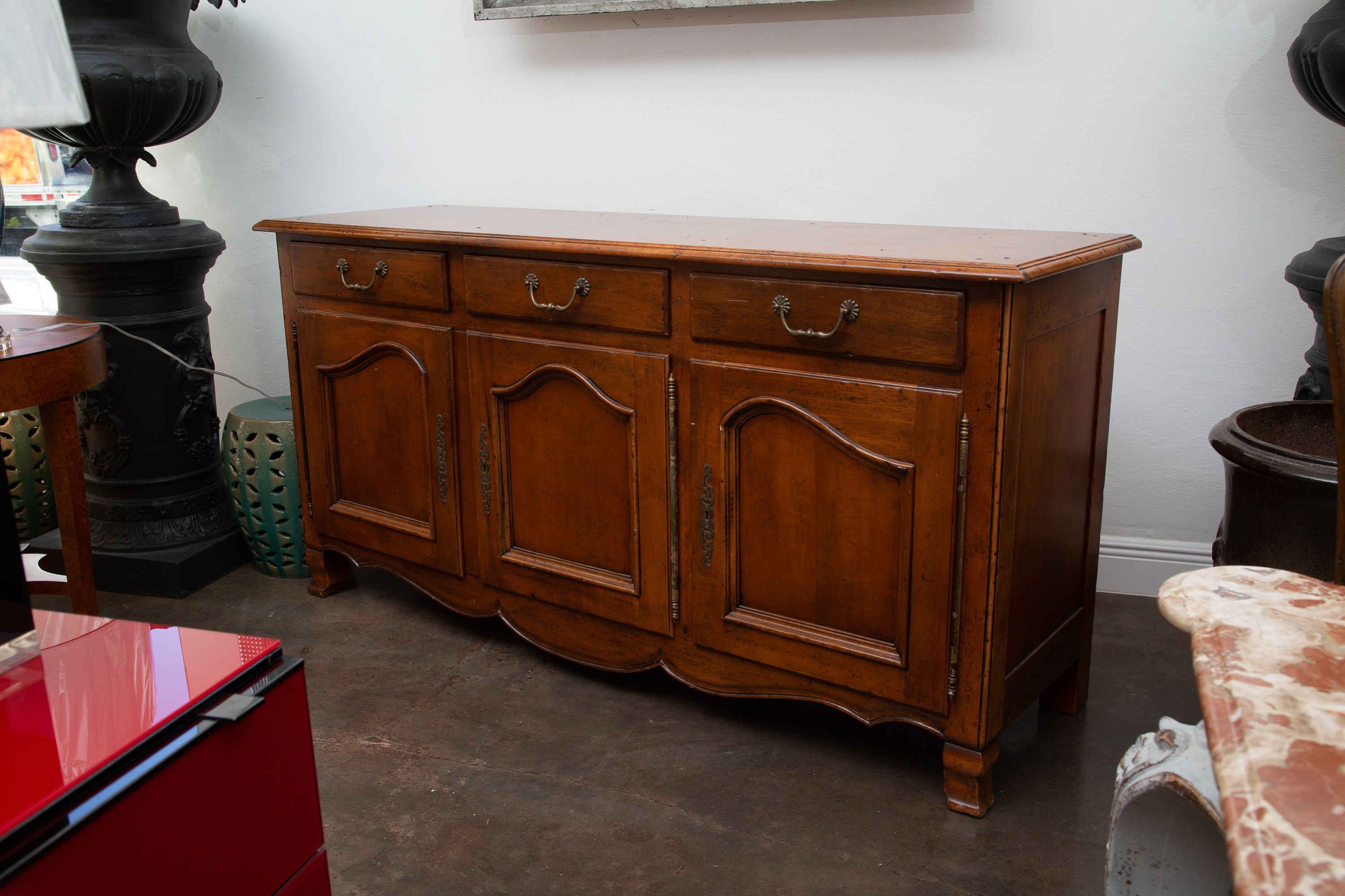 This is a mellow patinated French Louis XV style cherry buffet, the top with molded edge over three frieze drawers and three paneled cabinet doors. Below the doors is a nicely shaped apron and raised on modified cabriole feet.
